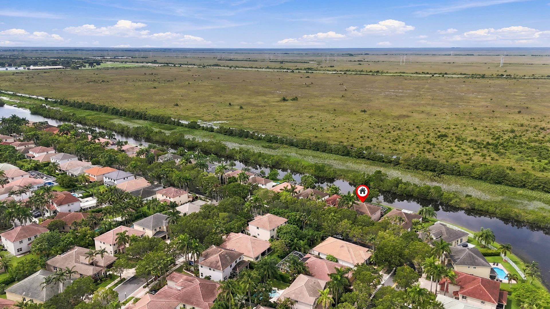 1020 Lavender Circle, Weston, FL 33327 Waterfront property with direct canal access, surrounded by mature trees and lush landscaping