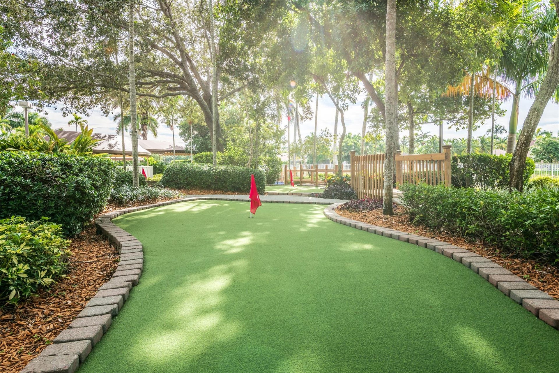 1020 Lavender Circle, Weston, FL 33327 Manicured putting green with lush landscaping, defined by paver edging