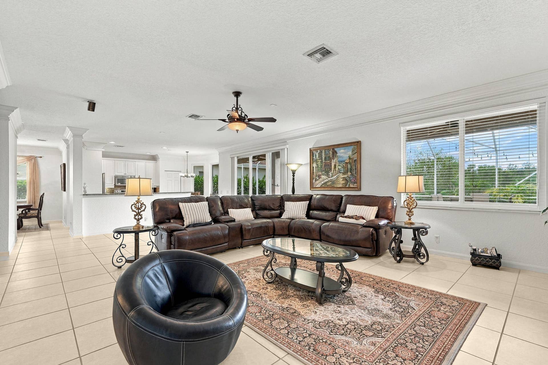 1020 Lavender Circle, Weston, FL 33327 Spacious living area featuring tile flooring, crown molding, a ceiling fan, and large windows with blinds