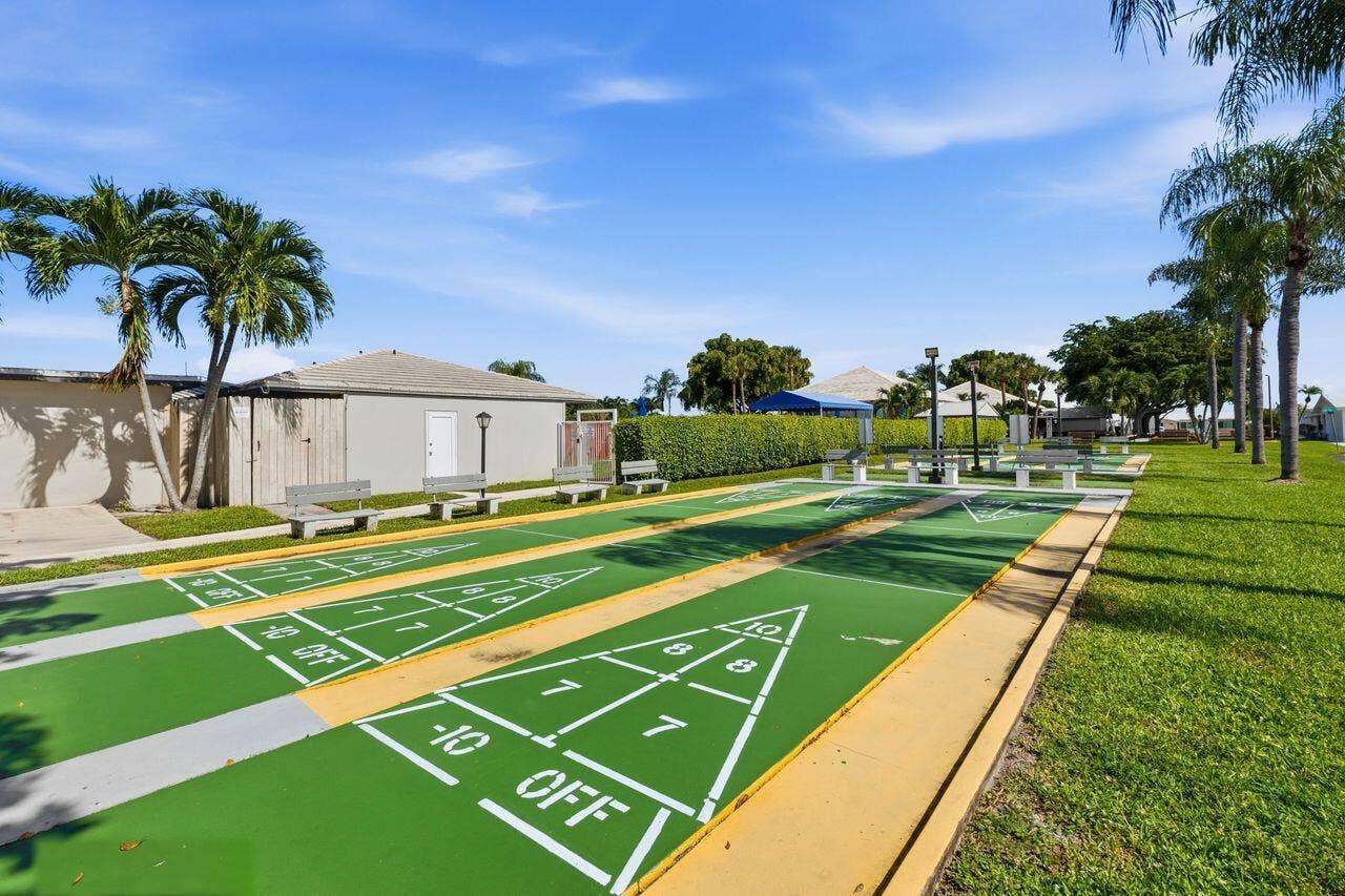 1003 SW 17th Street, Boynton Beach, FL 33426 Community shuffleboard courts with multiple lanes, surrounded by mature palm trees and lush green landscaping