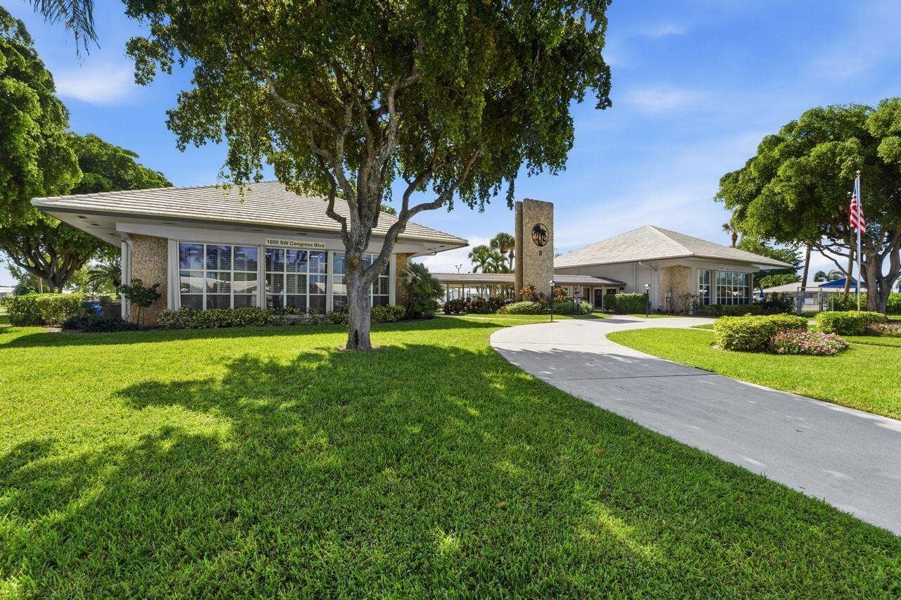 1003 SW 17th Street, Boynton Beach, FL 33426 Expansive lawn with mature trees and a paved driveway leading to the Clubhouse with all the amenities