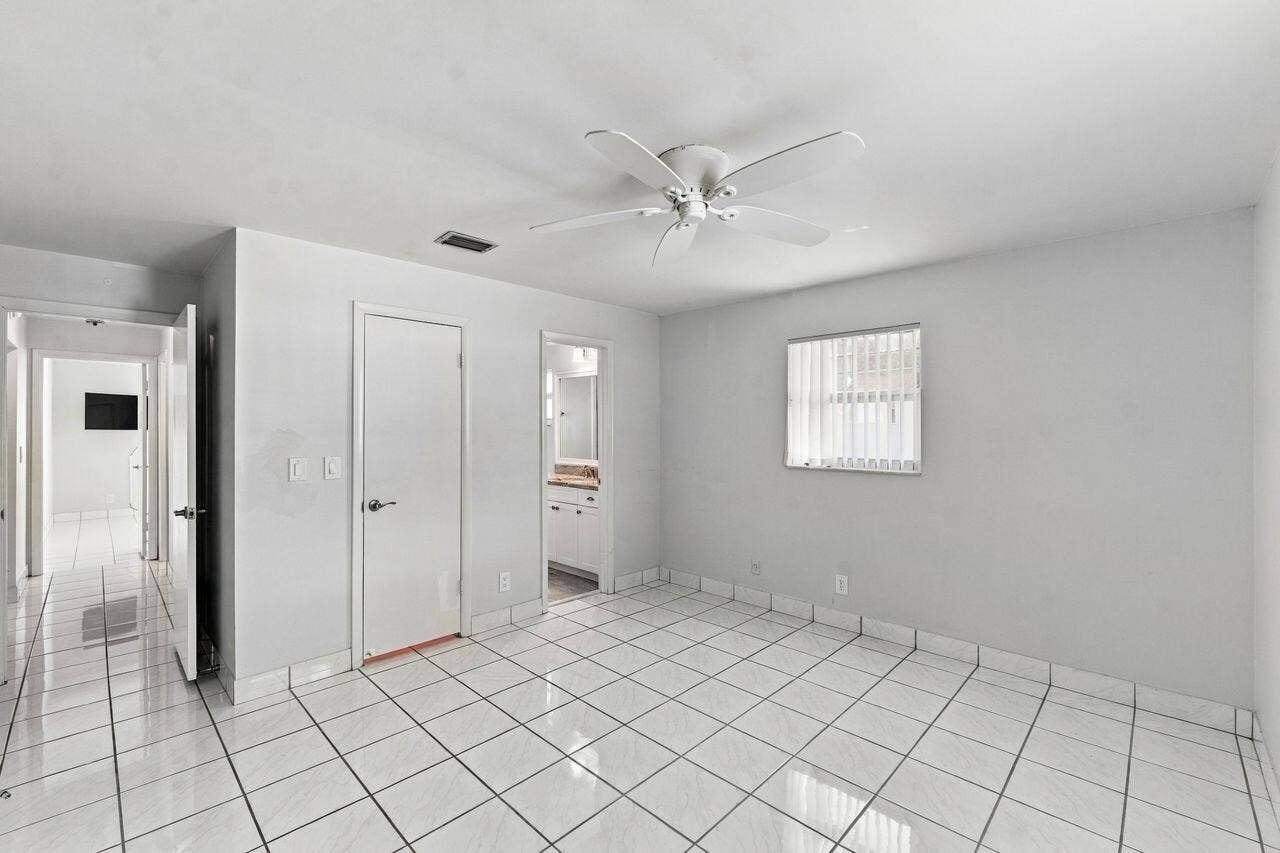 1003 SW 17th Street, Boynton Beach, FL 33426 White tile flooring, ceiling fan, white paneled doors, and lots of light