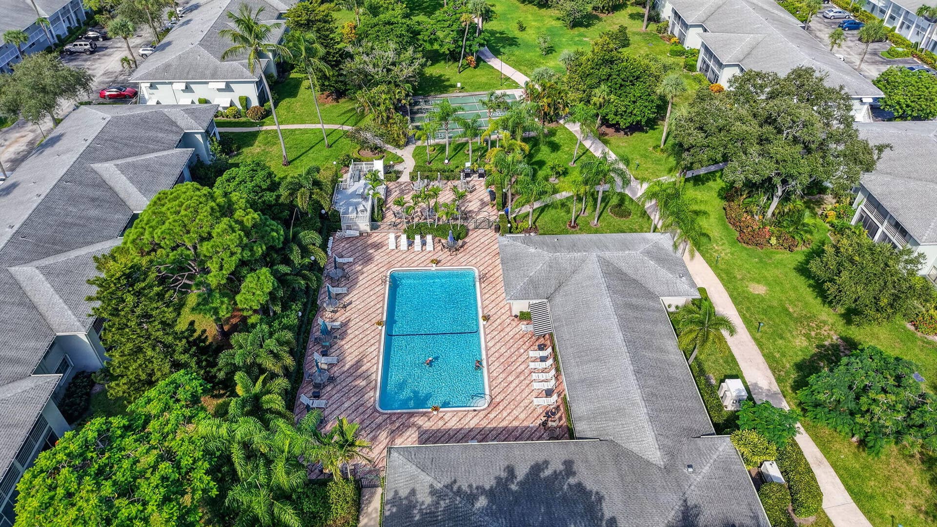 2320 SW 22nd Avenue, #211, Delray Beach, FL 33445 Resort-style pool with surrounding lounge chairs, paved pool deck, and mature landscaping