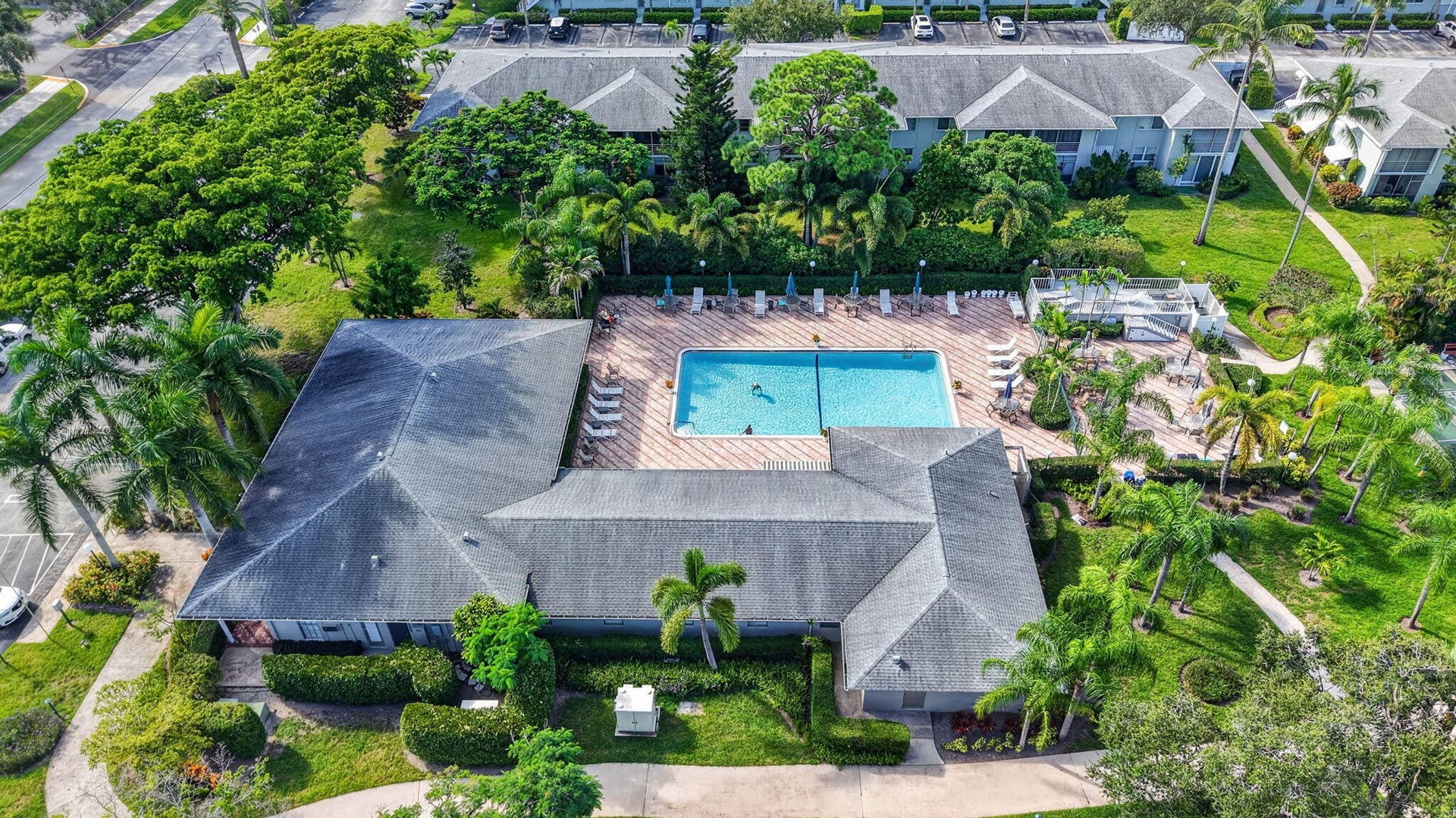 2320 SW 22nd Avenue, #211, Delray Beach, FL 33445 Expansive community grounds featuring a central swimming pool, surrounding lounge areas, and lush landscaping