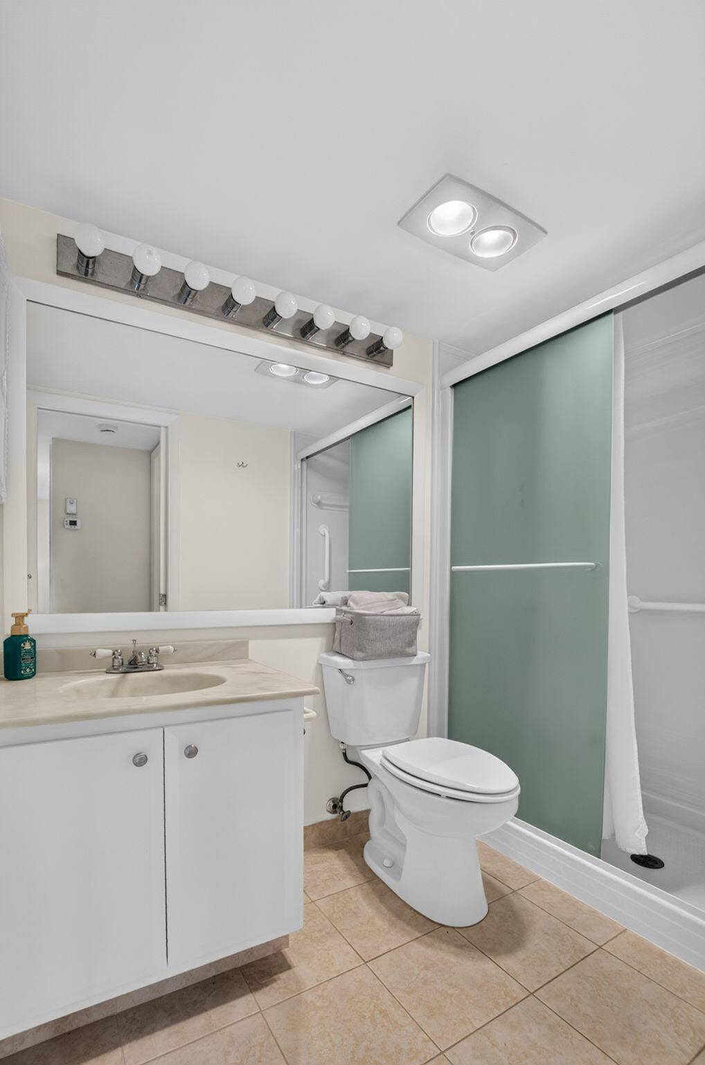 2320 SW 22nd Avenue, #211, Delray Beach, FL 33445 Guest bath with white vanity with a neutral-toned countertop, and shower enclosure with frosted glass panels