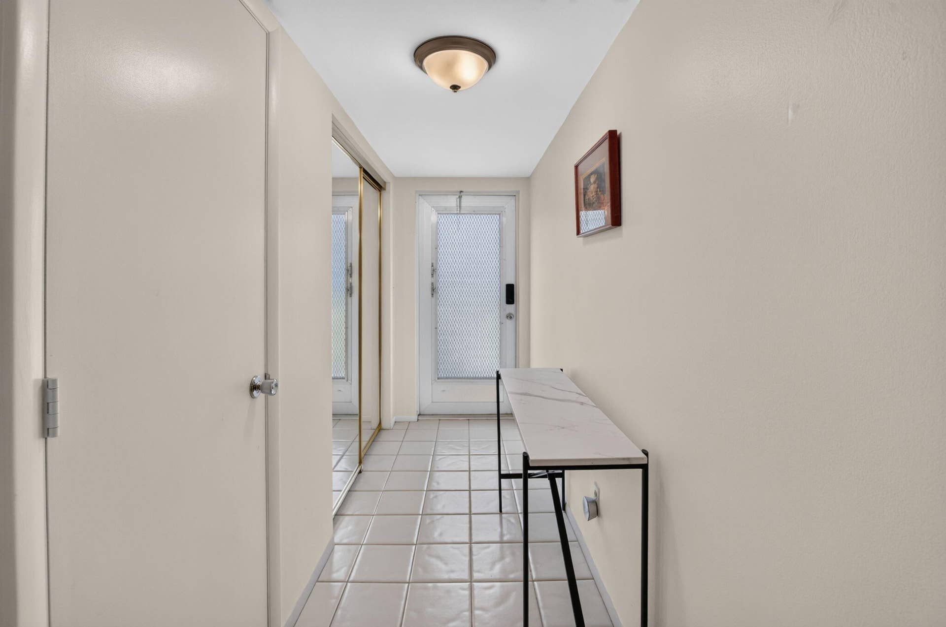 2320 SW 22nd Avenue, #211, Delray Beach, FL 33445 Entryway featuring tile flooring, a semi-flush ceiling light fixture, and a mirrored closet with gold-tone framing