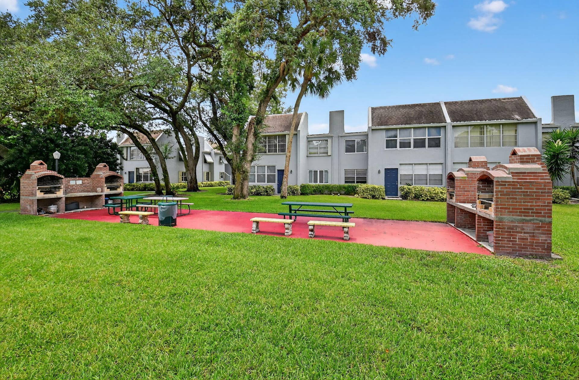 2320 SW 22nd Avenue, #211, Delray Beach, FL 33445 Expansive lawn area featuring multiple brick barbecue stations and picnic tables