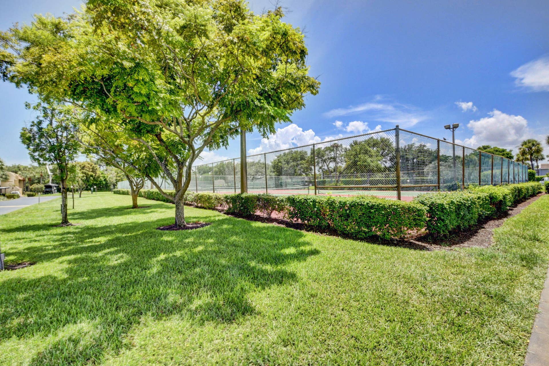 2320 SW 22nd Avenue, #211, Delray Beach, FL 33445 Tennis court surrounded by manicured hedges and mature trees