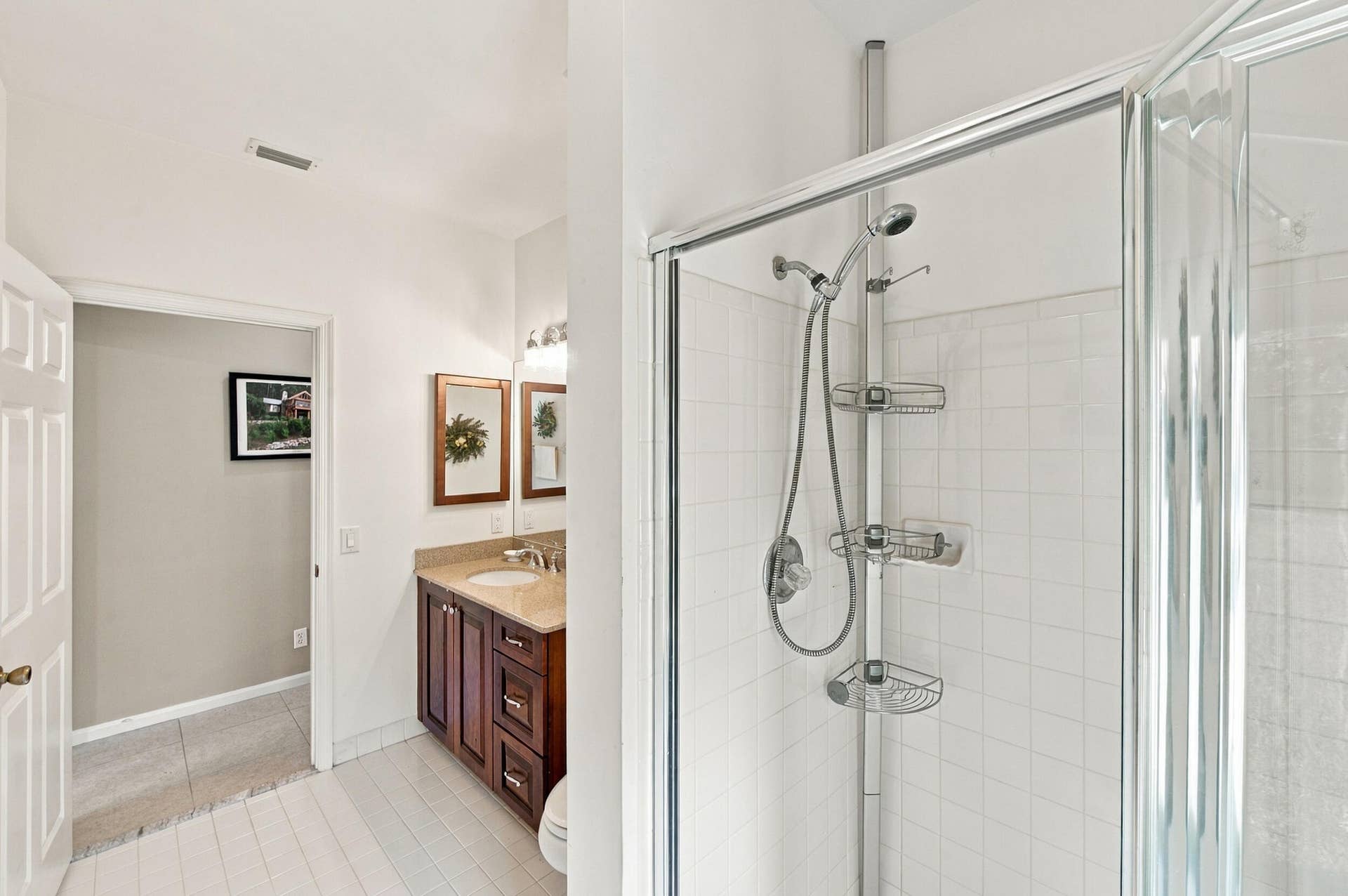1985 Landing Way, Weston, FL 33326 Glass-enclosed shower with white tiled walls, wood-finish vanity with countertop, and a single sink with a dual-light fixture