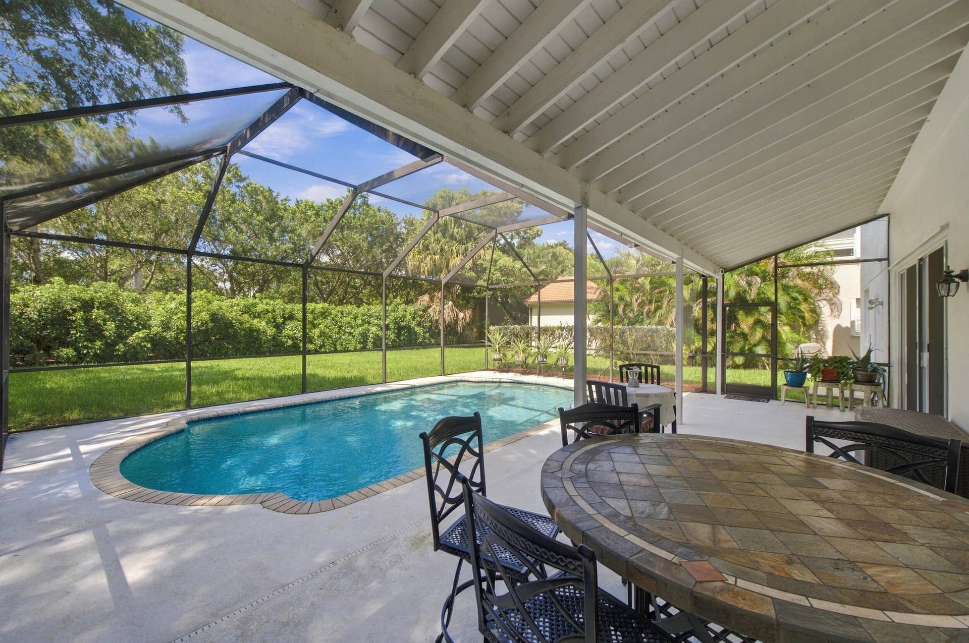 1985 Landing Way, Weston, FL 33326 Screened patio featuring a swimming pool, covered outdoor living space, and a tiled outdoor dining table