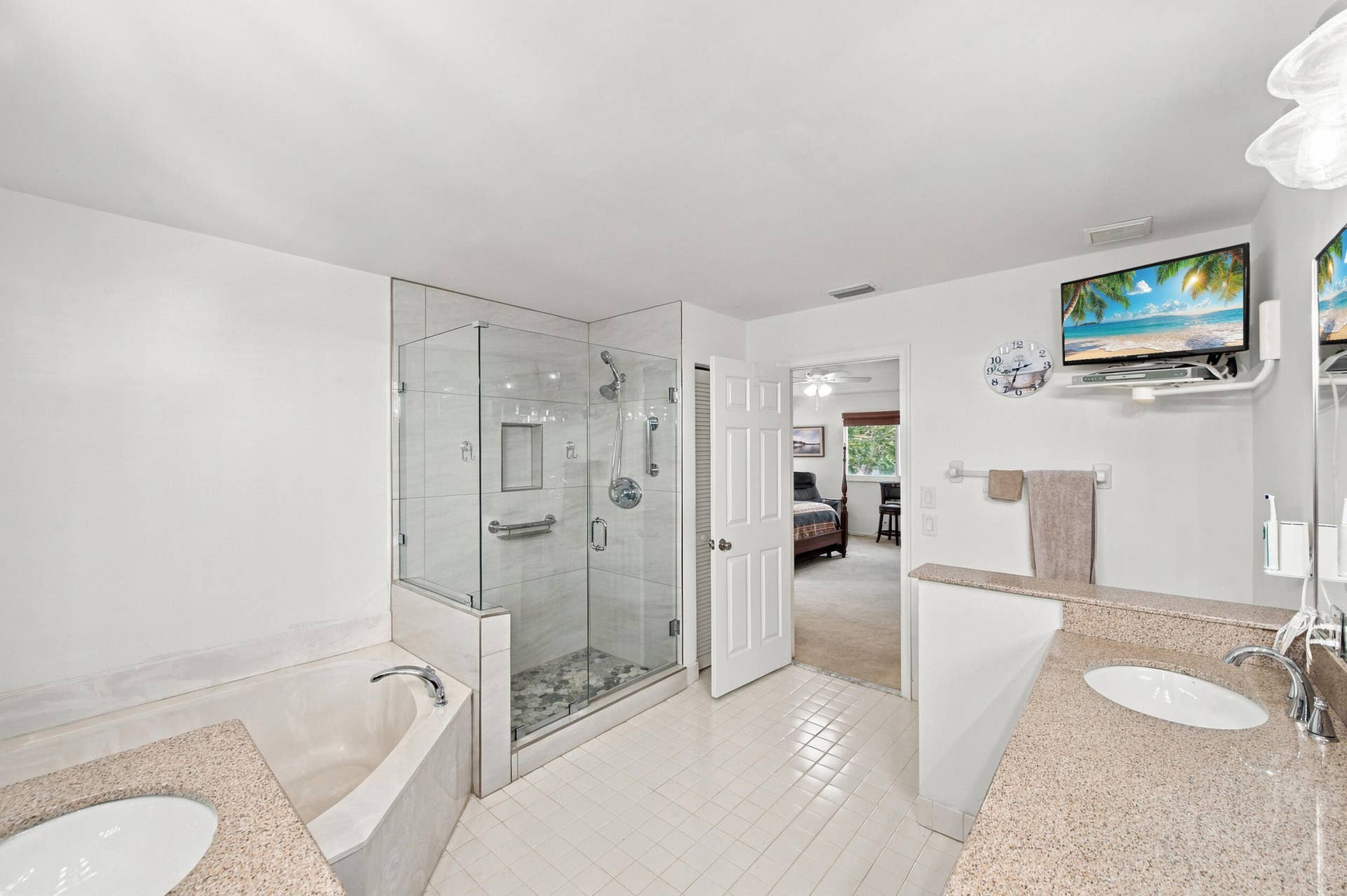 1985 Landing Way, Weston, FL 33326 Spacious bathroom featuring a glass-enclosed shower, built-in bathtub, and dual vanity with integrated sinks and stone-finish countertops