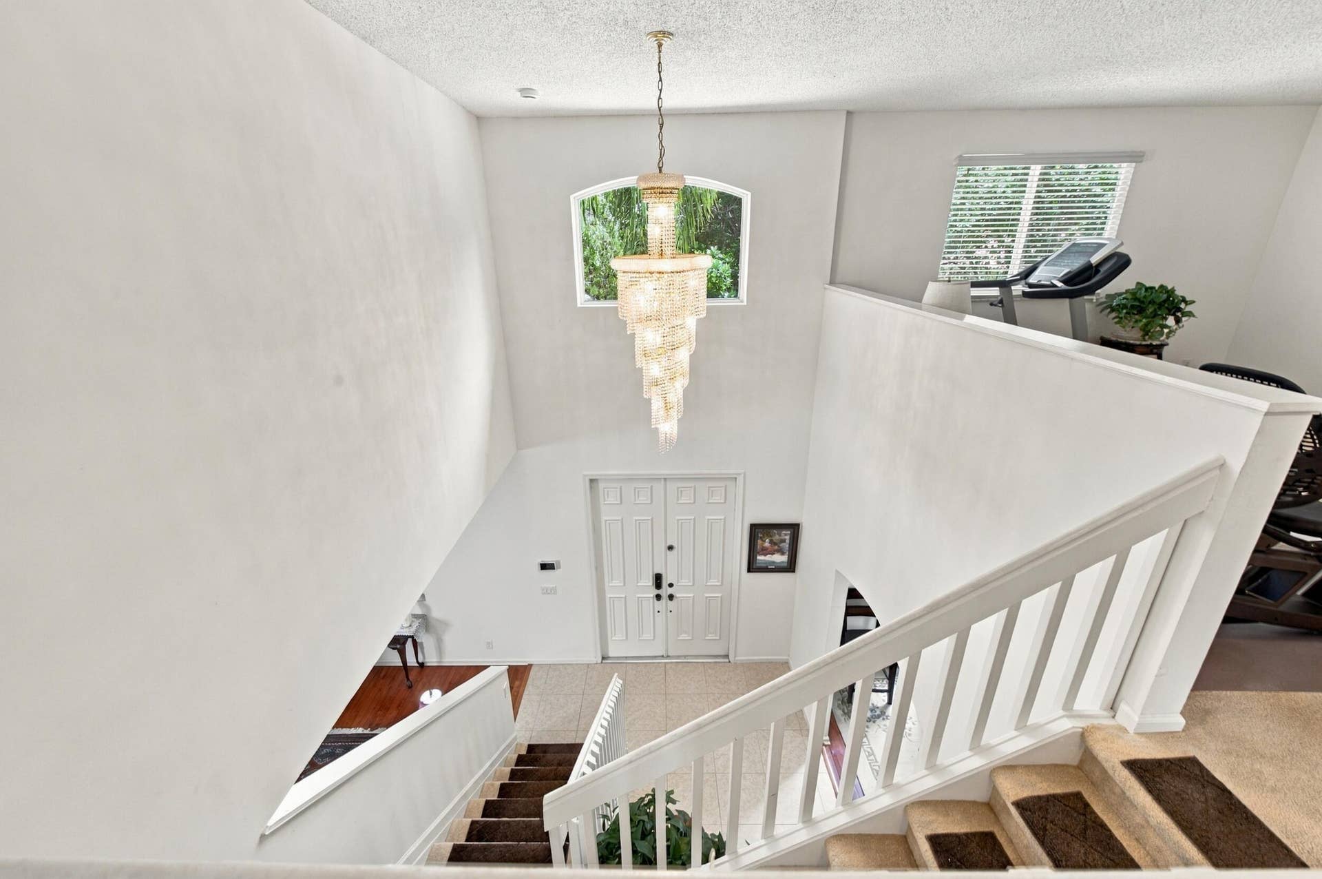 1985 Landing Way, Weston, FL 33326 Vaulted ceiling entry with a decorative chandelier, arched window, and double entry doors