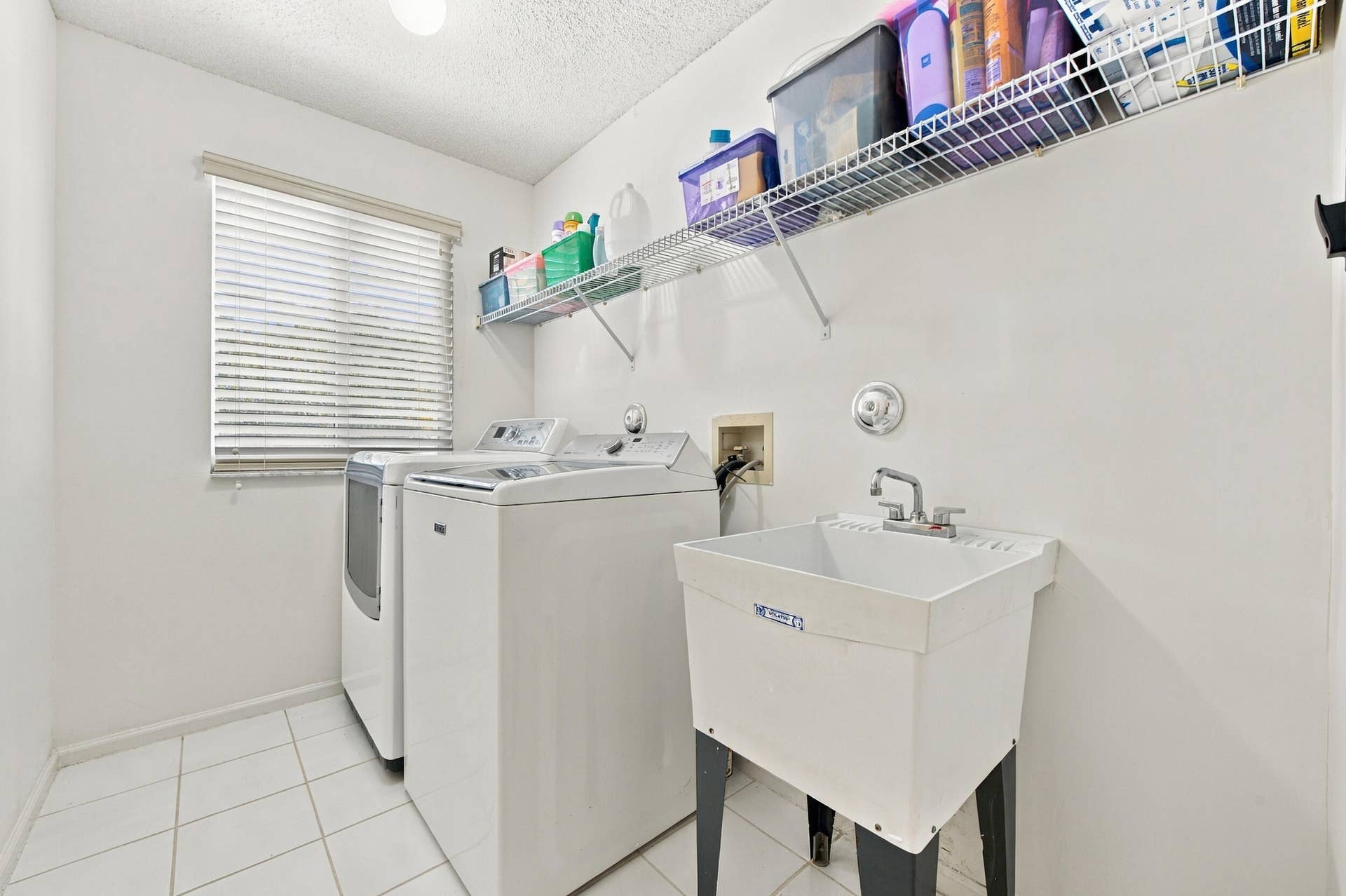1985 Landing Way, Weston, FL 33326 Dedicated laundry room featuring tile flooring, a utility sink, and wall-mounted wire shelving