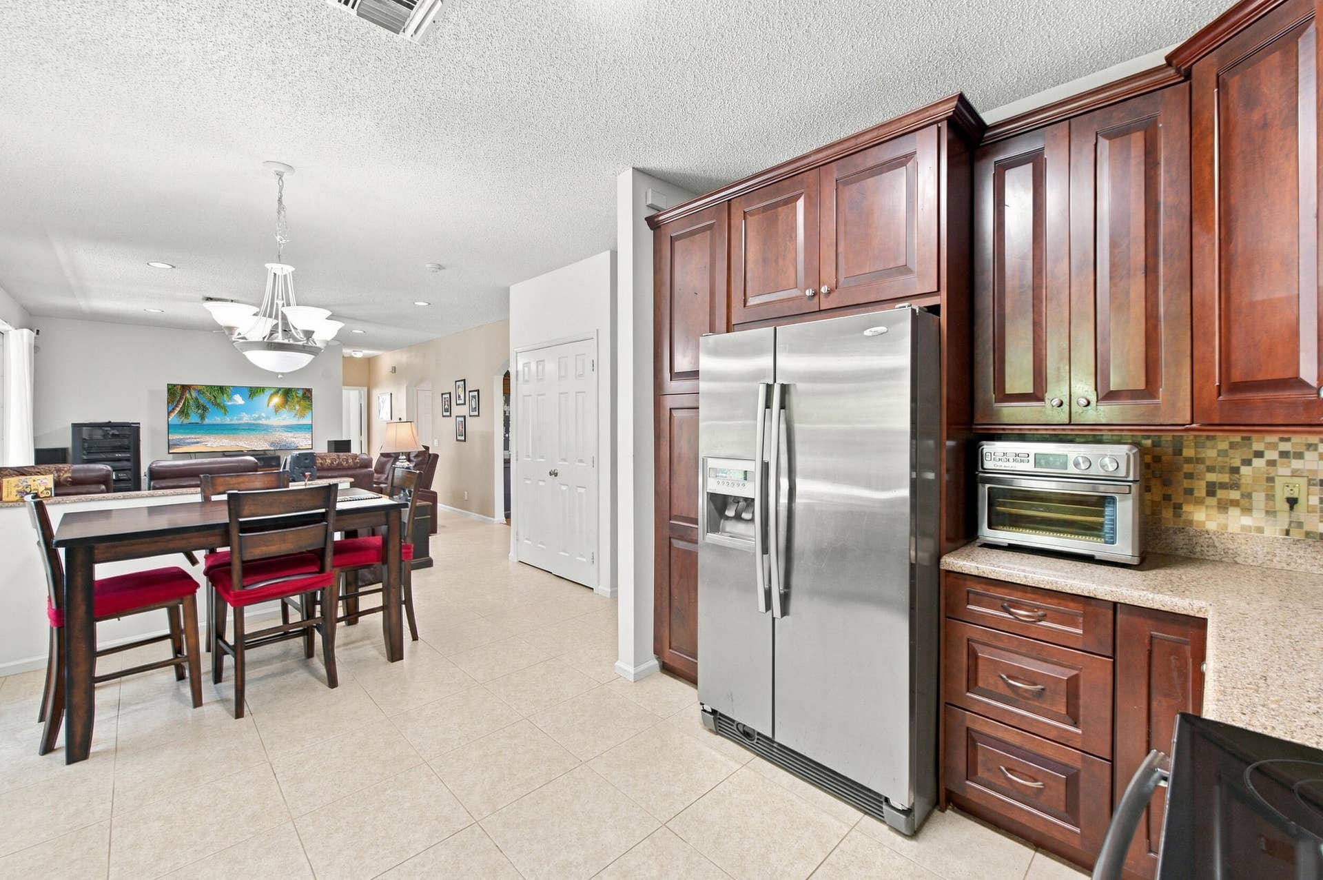 1985 Landing Way, Weston, FL 33326 Kitchen featuring wood-finish cabinetry, stainless steel refrigerator, and mosaic tile backsplash
