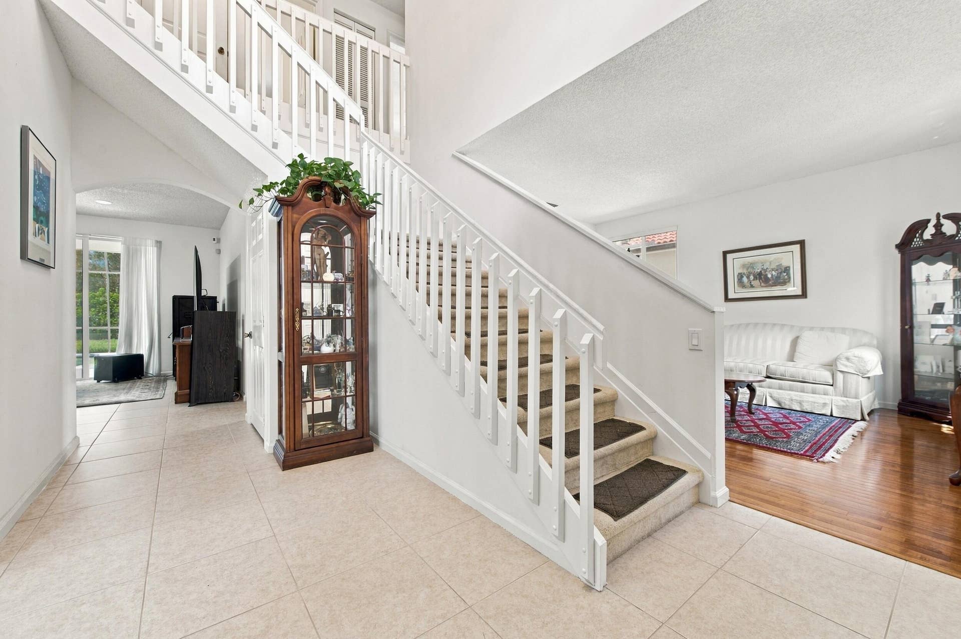 1985 Landing Way, Weston, FL 33326 Two-story foyer with tile flooring, white staircase, and an upper-level landing with matching balusters