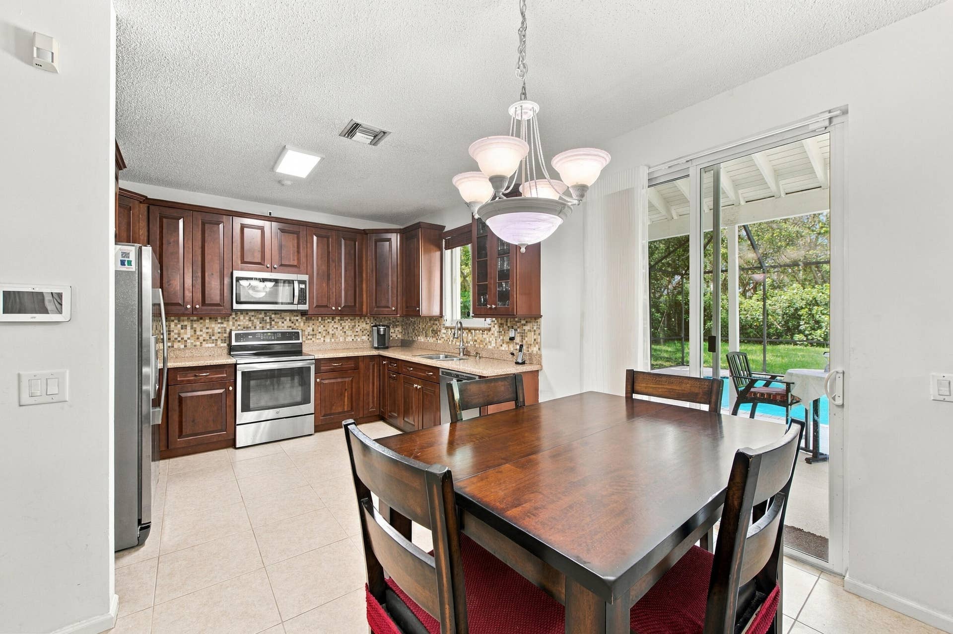 1985 Landing Way, Weston, FL 33326 Kitchen featuring wood cabinetry, stainless steel appliances, and a mosaic tile backsplash