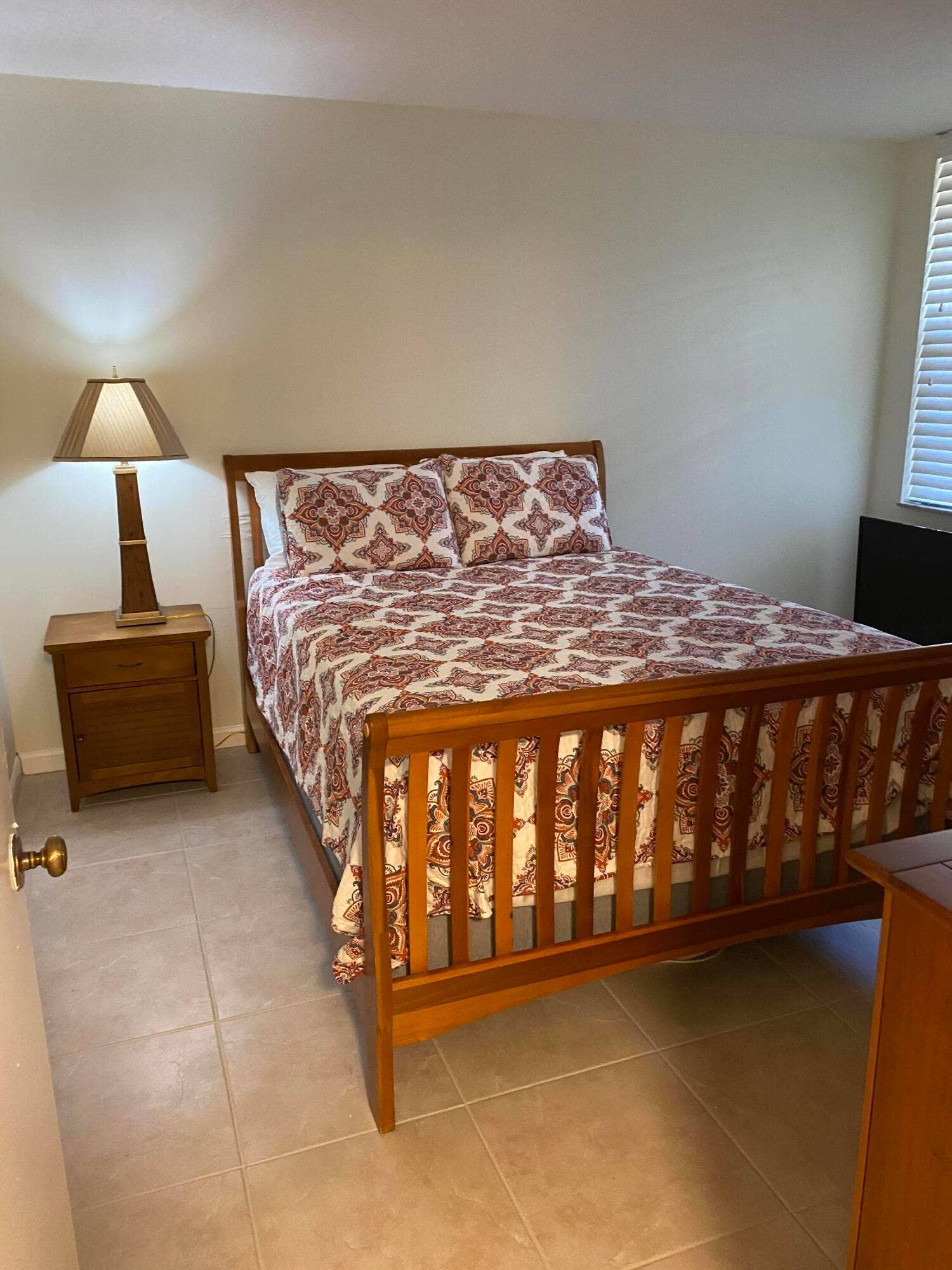 Recessed lighting, light tile flooring, white vertical blinds, and a built-in wooden bed frame