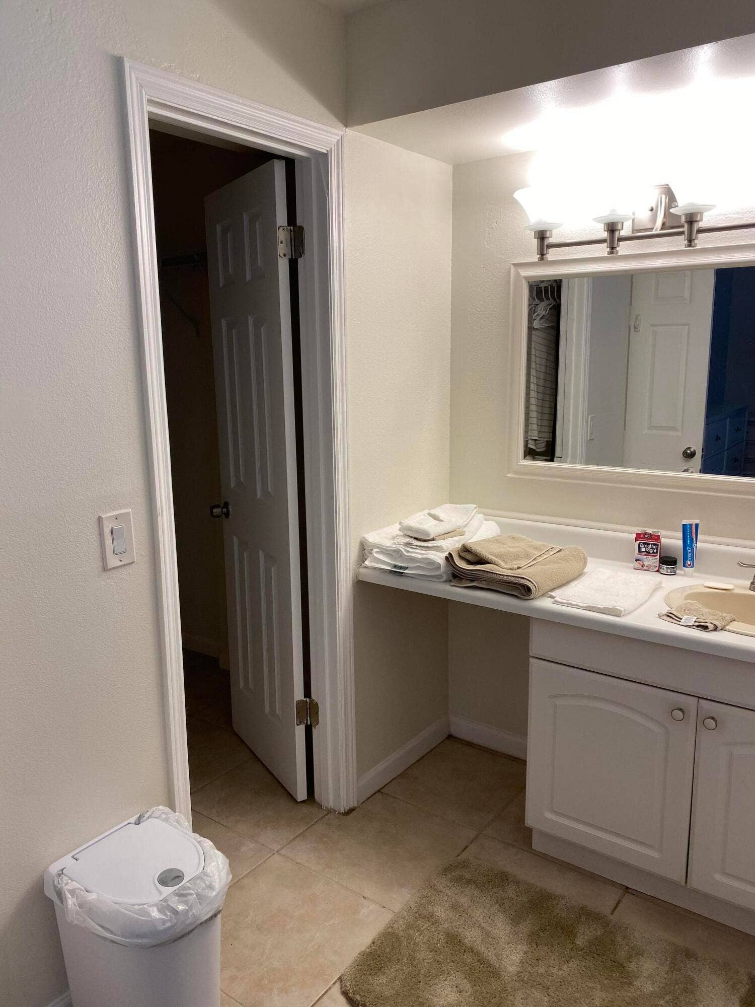 Vanity with integrated sink, dual-door base cabinet, and brushed nickel light fixture