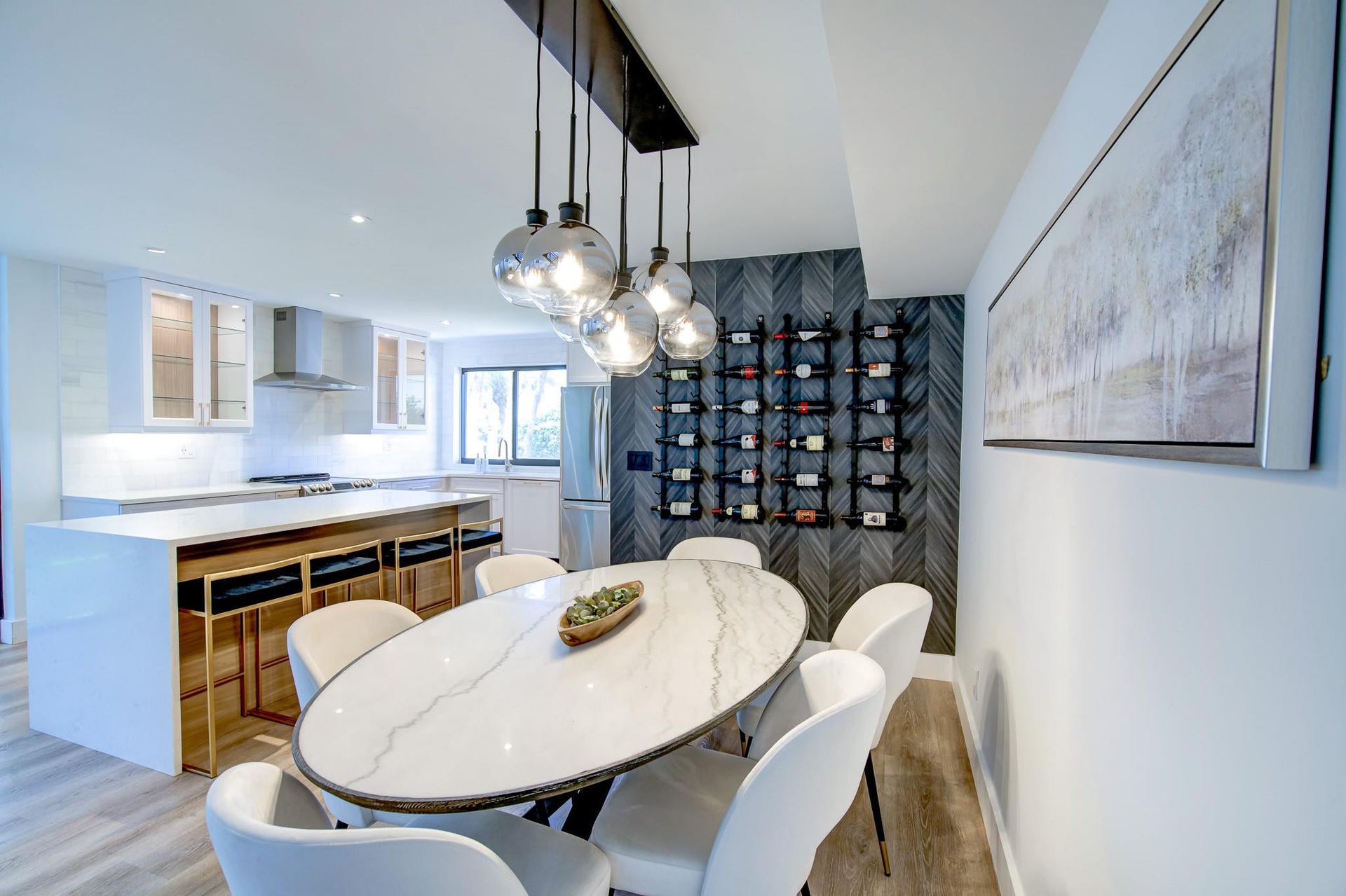 Open-concept kitchen and dining area featuring a kitchen island with seating, a wine rack wall, and wood-finish flooring