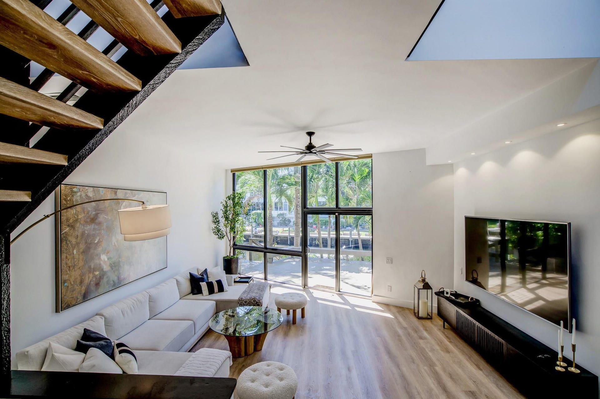 Open-riser staircase with wood-finish treads, expansive windows, wood-finish flooring, recessed lighting, and a ceiling fan