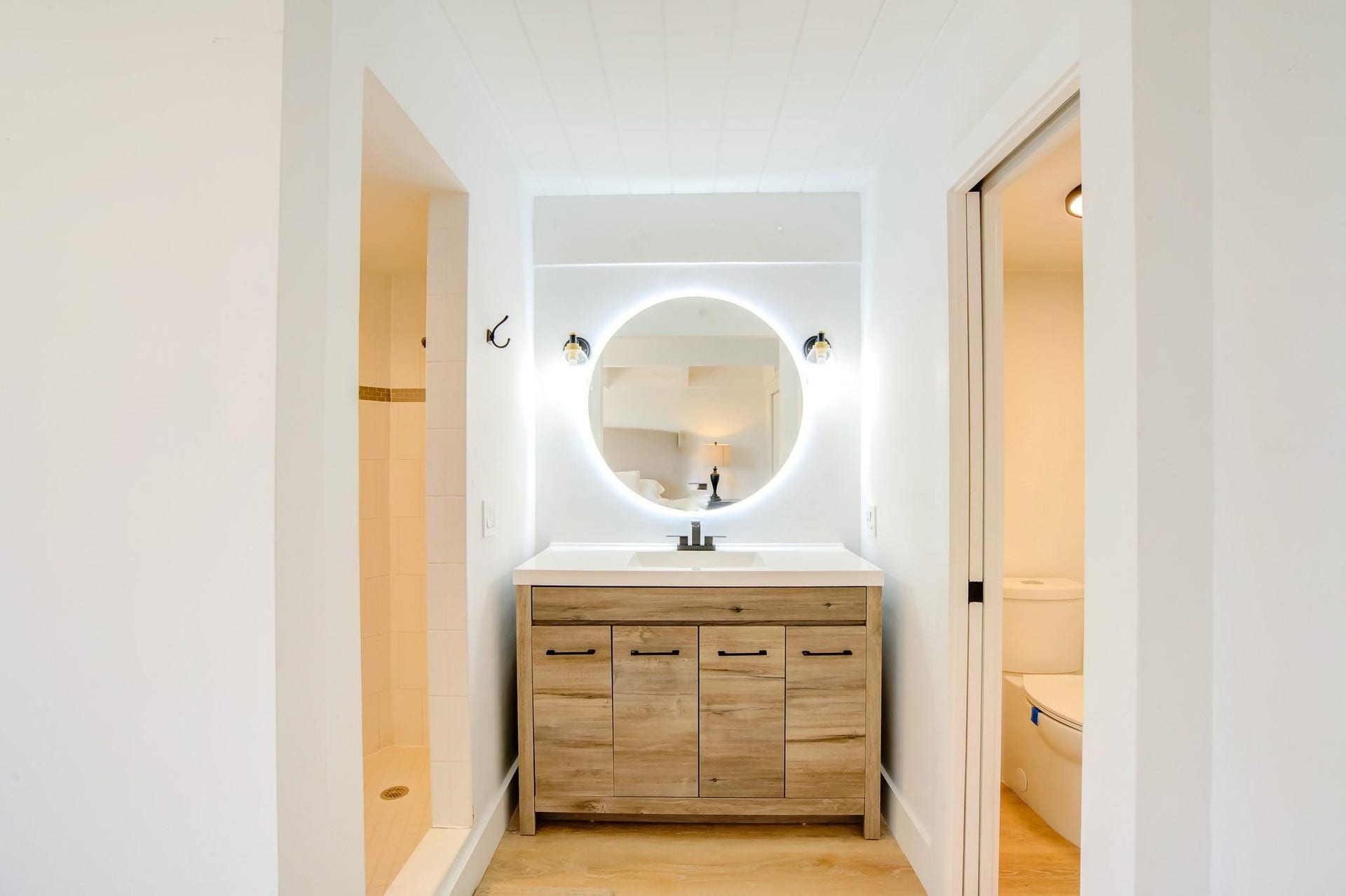Vanity with wood-finish cabinetry, integrated sink, and undermount faucet