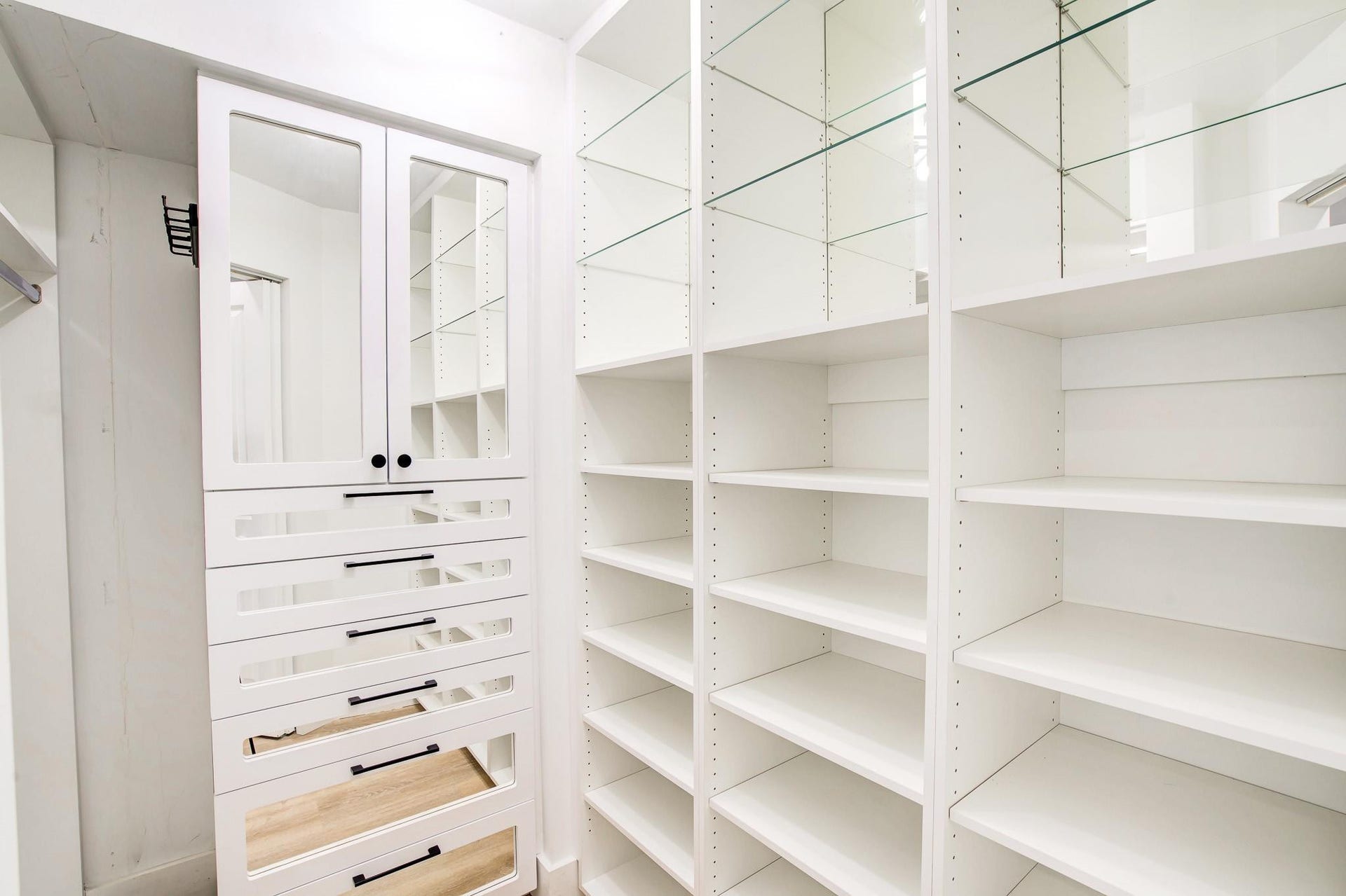Custom built-in storage system with white cabinetry and varied shelving