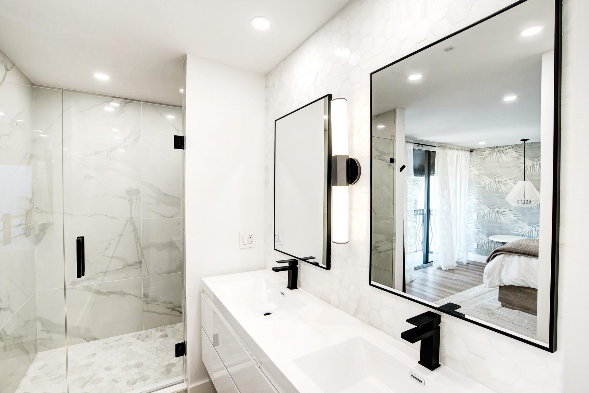 Contemporary bathroom featuring a dual vanity, frameless glass shower enclosure, large format tile shower walls, and a tiled shower floor