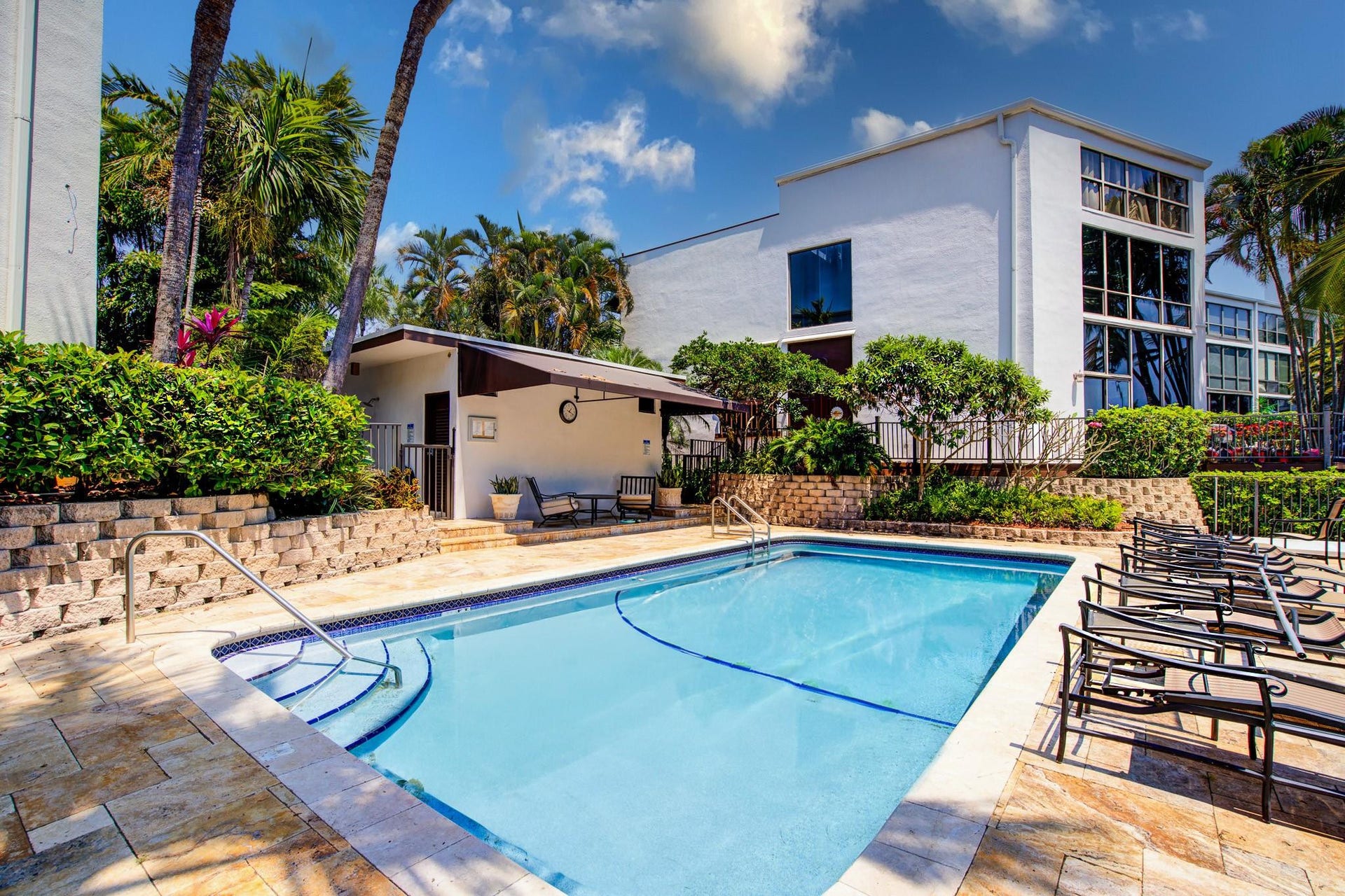 Rectangular swimming pool with tiled steps and metal handrails