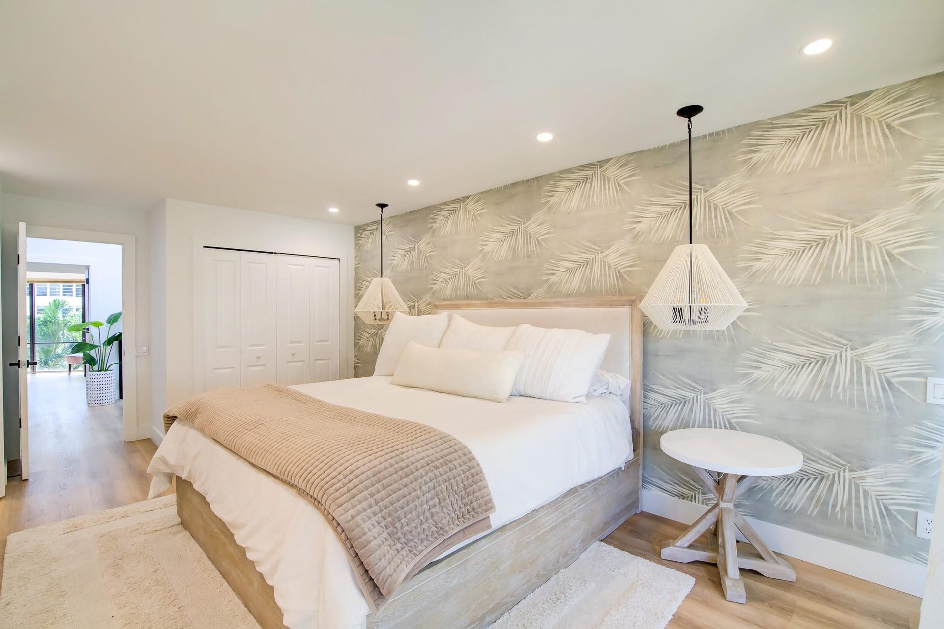 Wood-finish flooring, recessed lighting, and a feature wall with botanical pattern