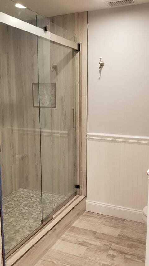 Seamless shower door and decorative bead board in bathroom