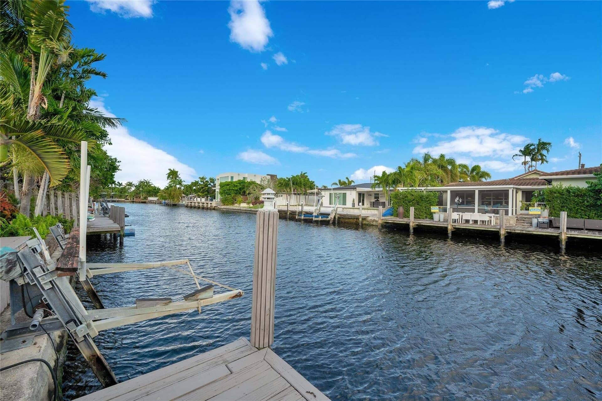 2142 NE 17th Avenue, Wilton Manors, FL 33305 Waterfront property featuring a private dock and lush tropical landscaping