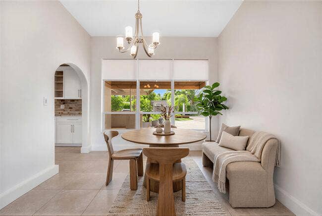 2142 NE 17th Avenue, Wilton Manors, FL 33305 Virtually Staged. Recessed window with exterior scenery, contemporary chandelier, tiled flooring and arched doorway