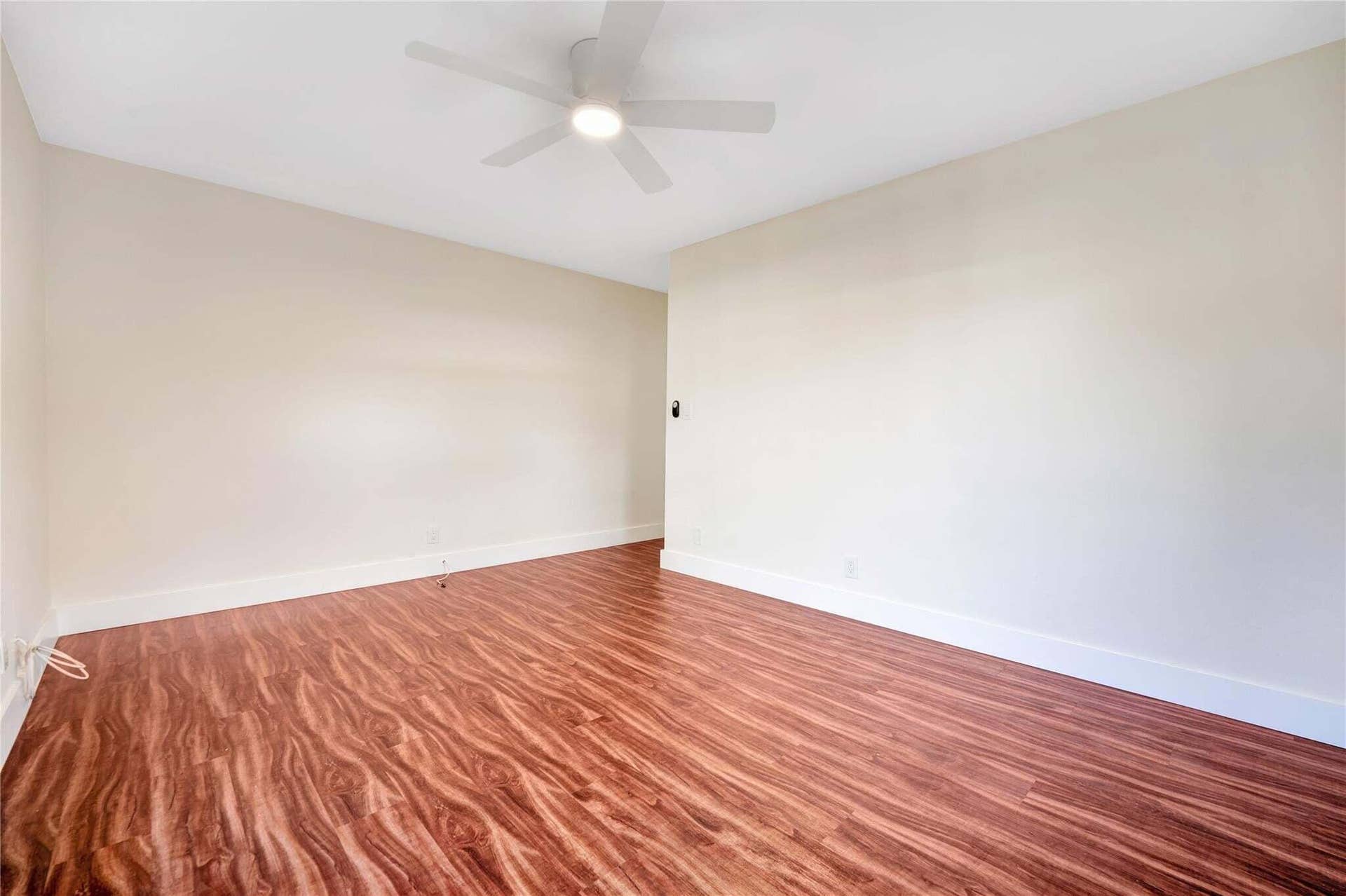 2142 NE 17th Avenue, Wilton Manors, FL 33305 Wood-finish flooring, white walls, and a ceiling fan with integrated lighting