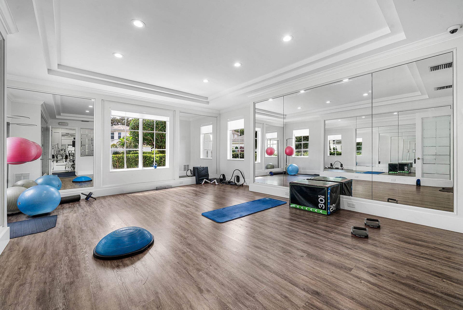 Spacious room featuring expansive mirrored wall, tray ceiling - invite your personal trainer