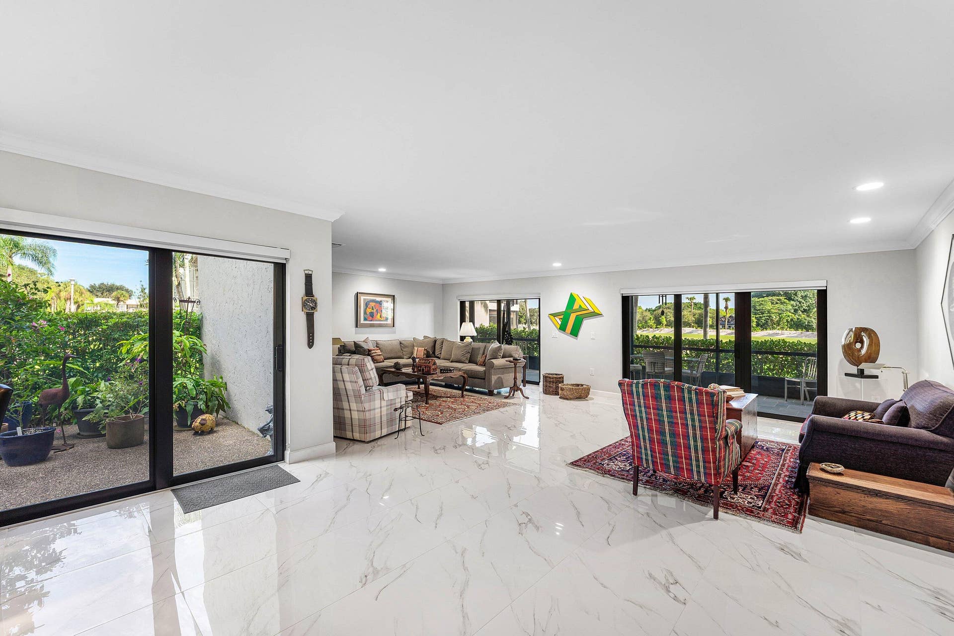 12 Stratford Drive E, #A, Boynton Beach, FL 33436 Expansive living area featuring white marble-look tile flooring, recessed lighting, and crown molding