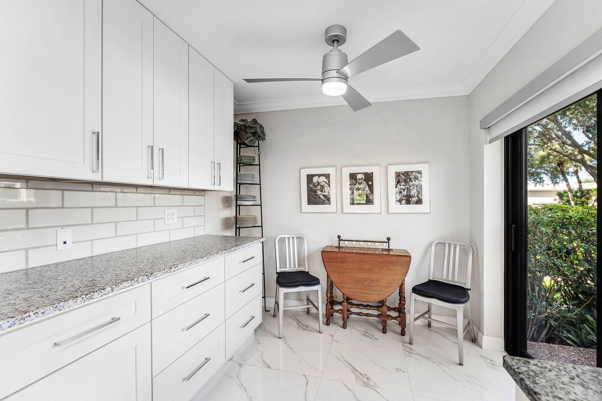 12 Stratford Drive E, #A, Boynton Beach, FL 33436 White shaker cabinetry with brushed nickel hardware, light-toned granite-finish countertops, white subway tile backsplash, and large-format porcelain tile flooring