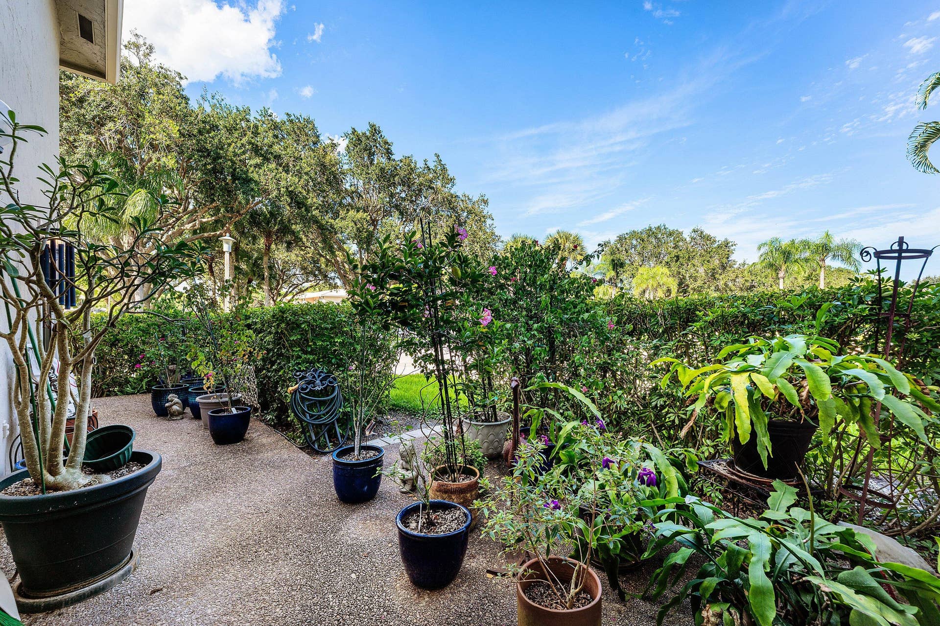 12 Stratford Drive E, #A, Boynton Beach, FL 33436 Landscaped outdoor area with a gravel pathway and lush greenery