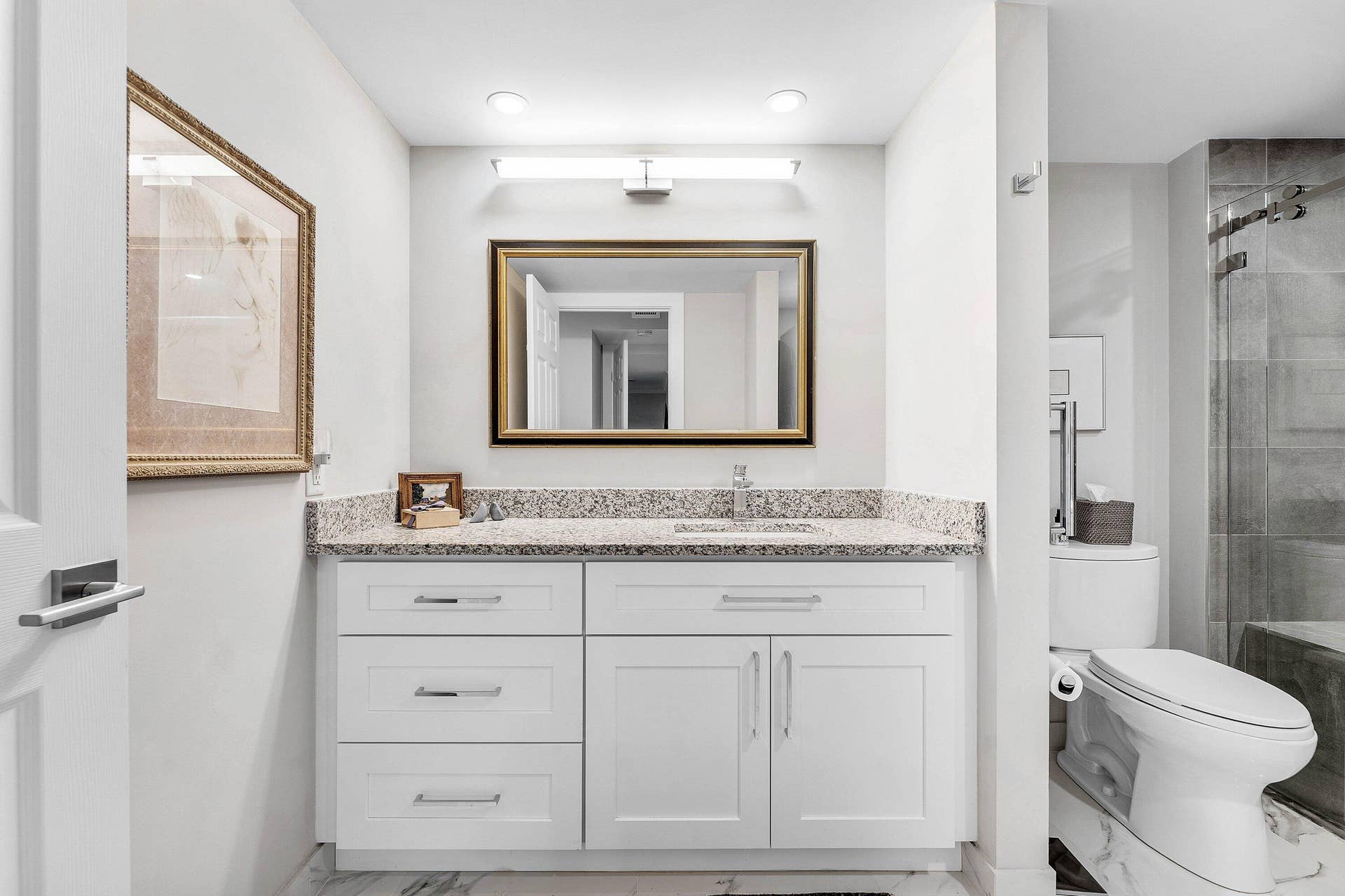 12 Stratford Drive E, #A, Boynton Beach, FL 33436 White shaker-style vanity with a light granite countertop, undermount sink, and polished chrome fixtures