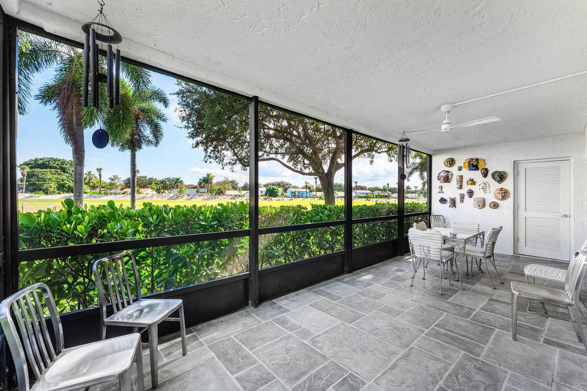 12 Stratford Drive E, #A, Boynton Beach, FL 33436 Enclosed screened patio featuring large format tile flooring, a textured ceiling, and a ceiling fan