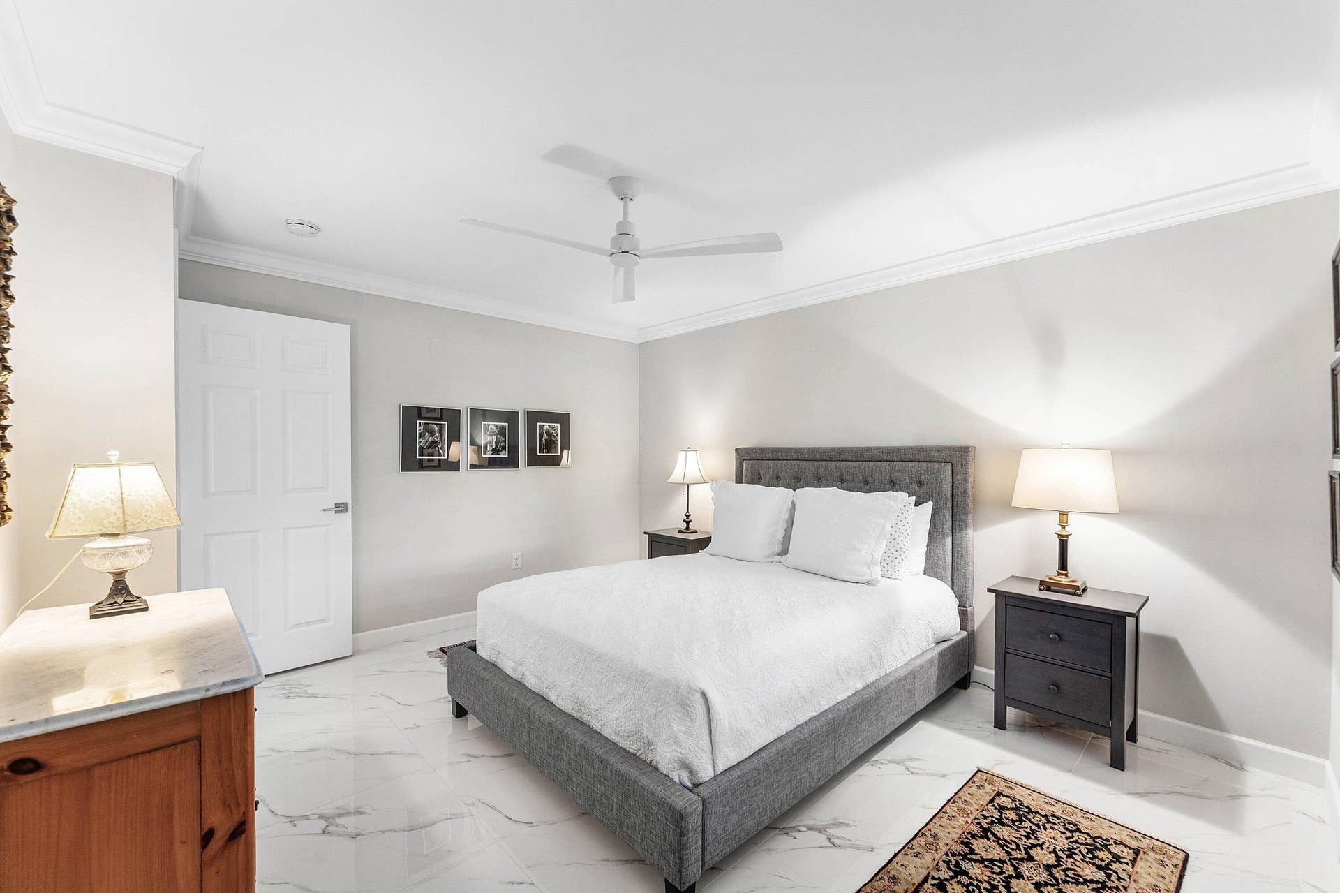 12 Stratford Drive E, #A, Boynton Beach, FL 33436 White paneled door, crown molding, ceiling fan, and white tile flooring