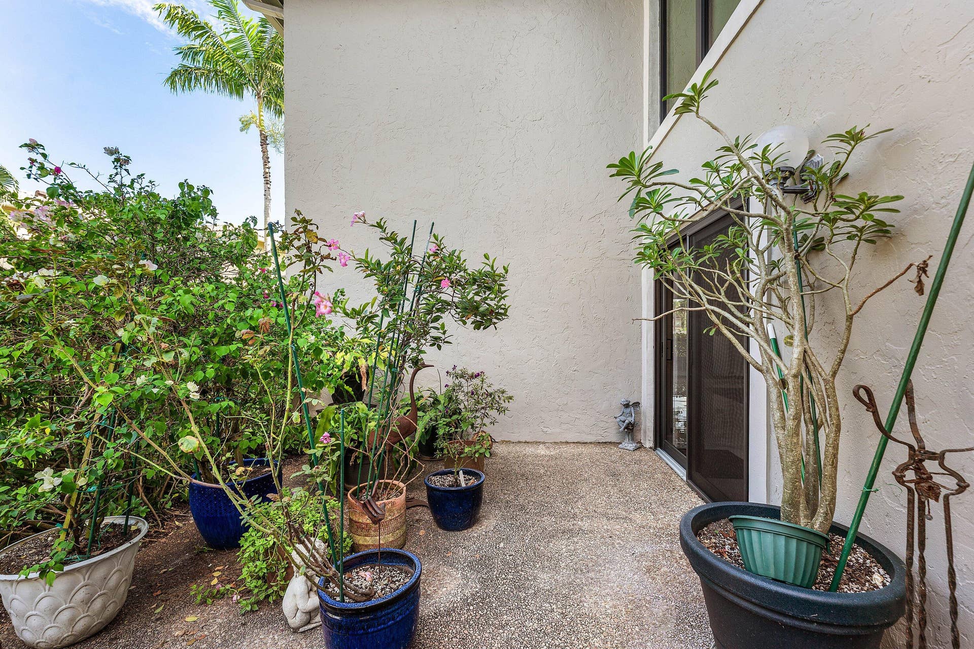 12 Stratford Drive E, #A, Boynton Beach, FL 33436 Outdoor patio with textured concrete flooring, stucco exterior, and a glass-paneled entry door