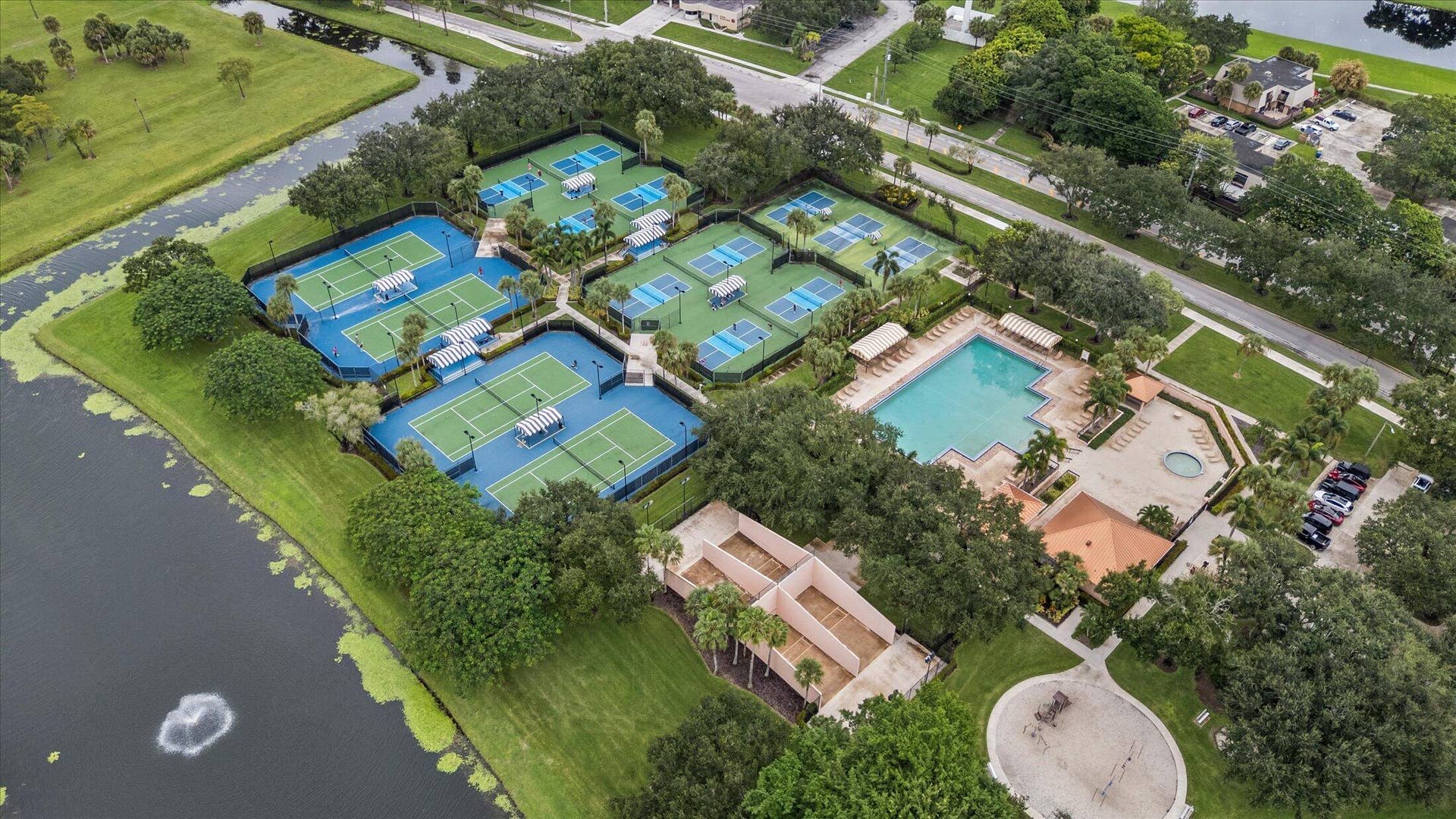 2890 ANTIETAM Lane, West Palm Beach, FL 33409 Multiple tennis courts, a swimming pool, and a spa with surrounding hardscaping