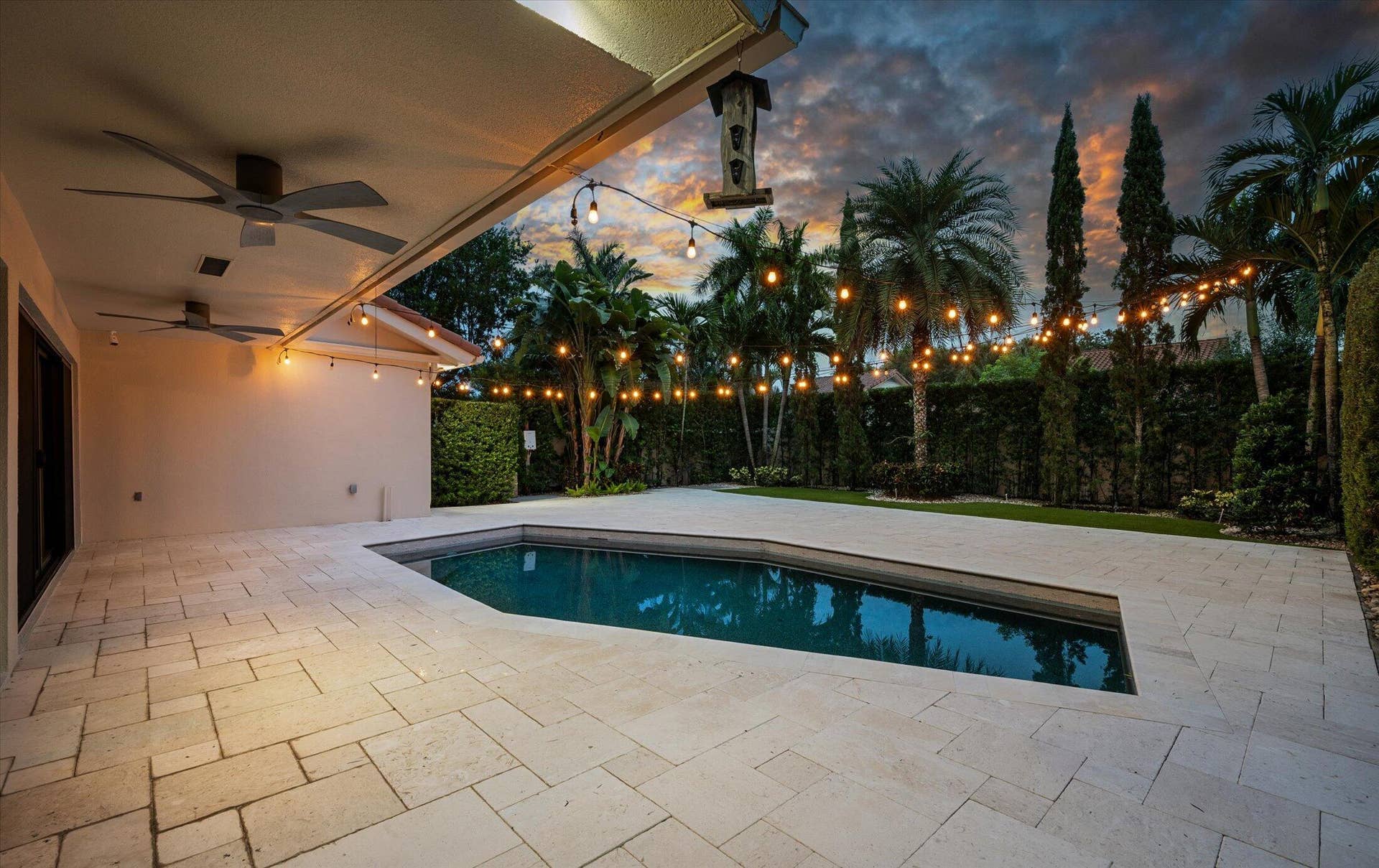 2890 ANTIETAM Lane, West Palm Beach, FL 33409 Expansive pool patio with light-toned paving stones, recessed lighting, and dual ceiling fans