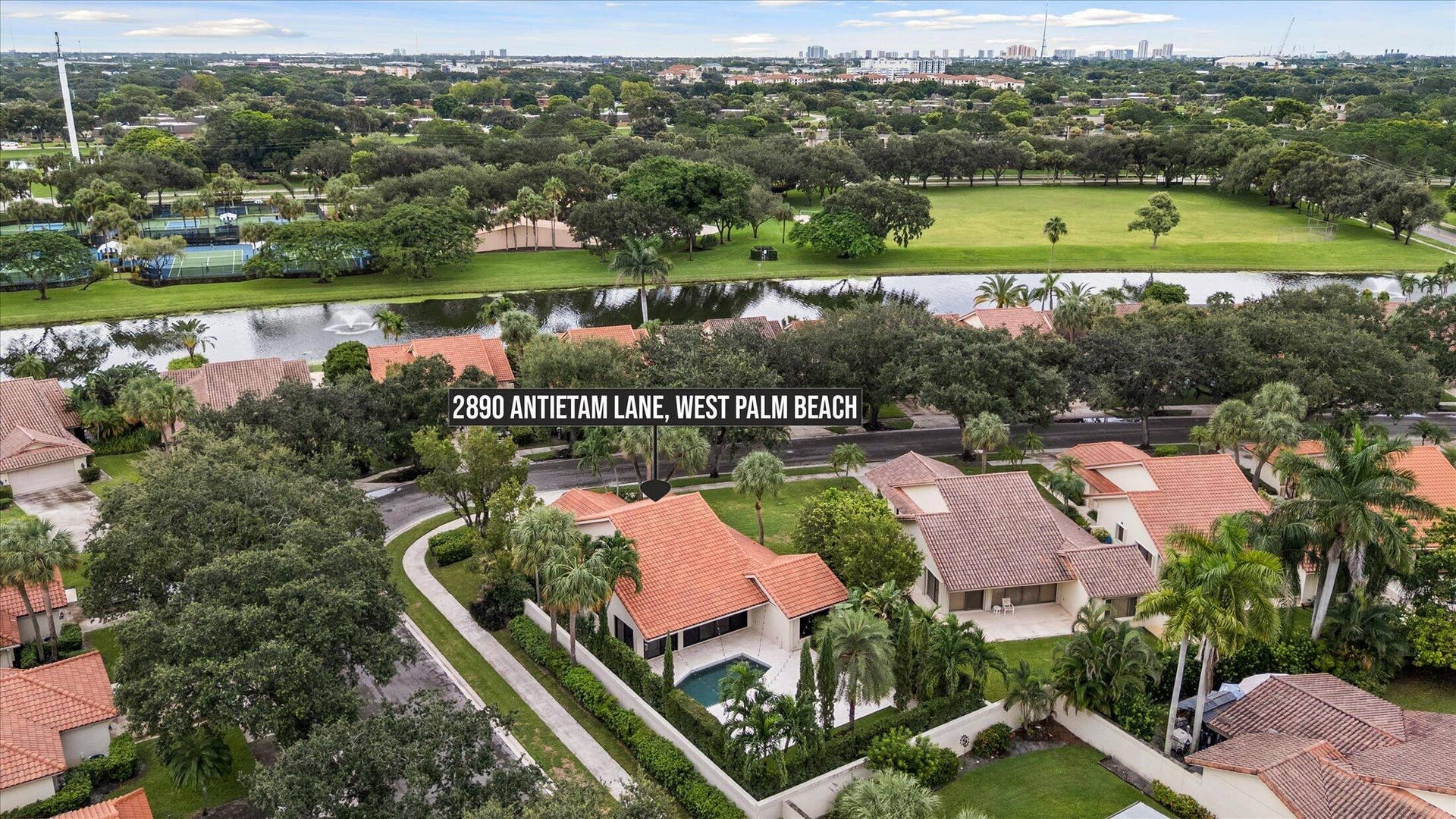 2890 ANTIETAM Lane, West Palm Beach, FL 33409 Residence with tiled roof, private swimming pool, and mature landscaping