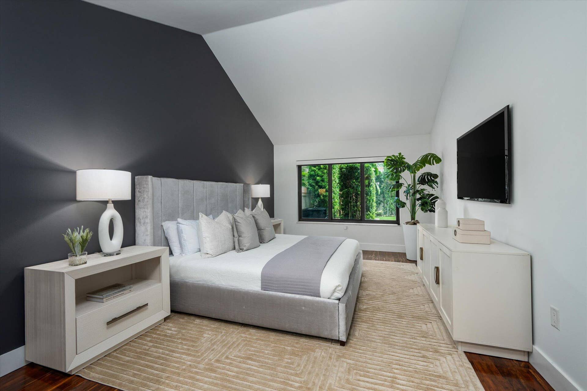2890 ANTIETAM Lane, West Palm Beach, FL 33409 Vaulted ceilings, dark accent wall, wood-finish flooring, and a large window