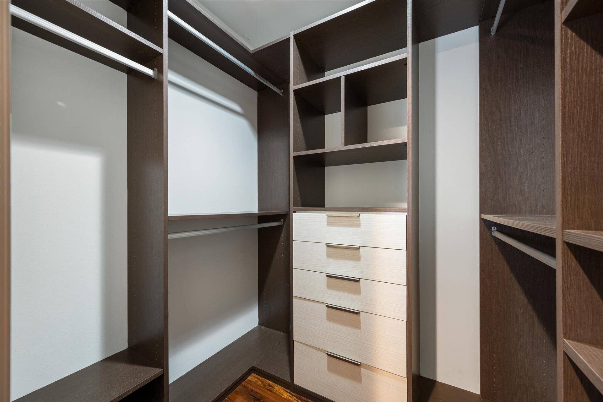 2890 ANTIETAM Lane, West Palm Beach, FL 33409 Custom closet system featuring dark wood-finish cabinetry, built-in shelving, multiple hanging rods, four light wood-finish drawers, and sleek drawer pulls