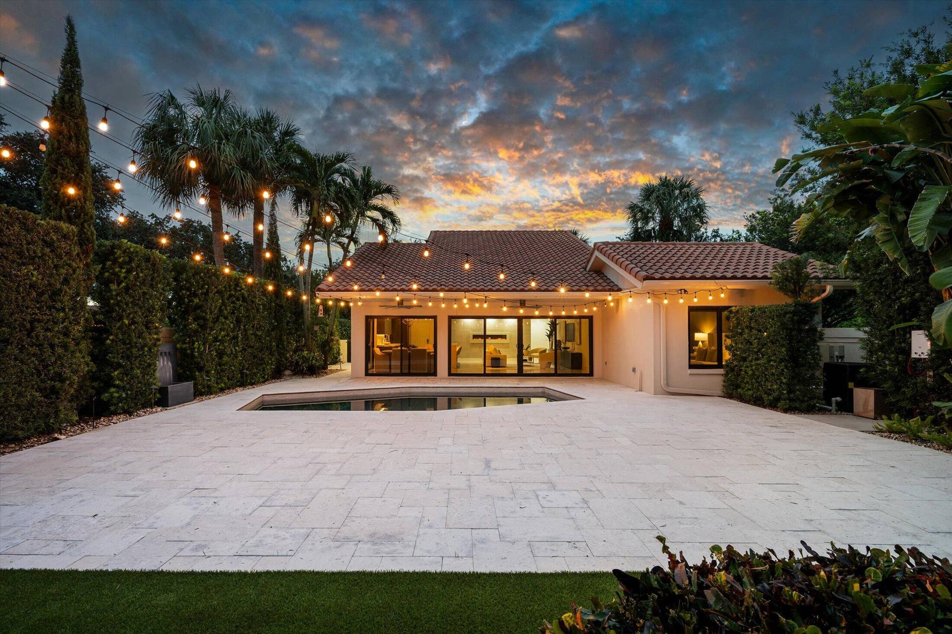 2890 ANTIETAM Lane, West Palm Beach, FL 33409 Pool area with extensive paver patio, lush perimeter landscaping, and a tile roof