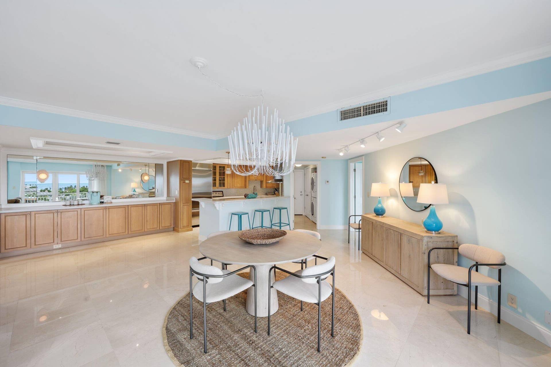 Expansive living and dining area create an impressive sense of openess, while walls of impact glass connect the interiors to the surrounding water and sky.