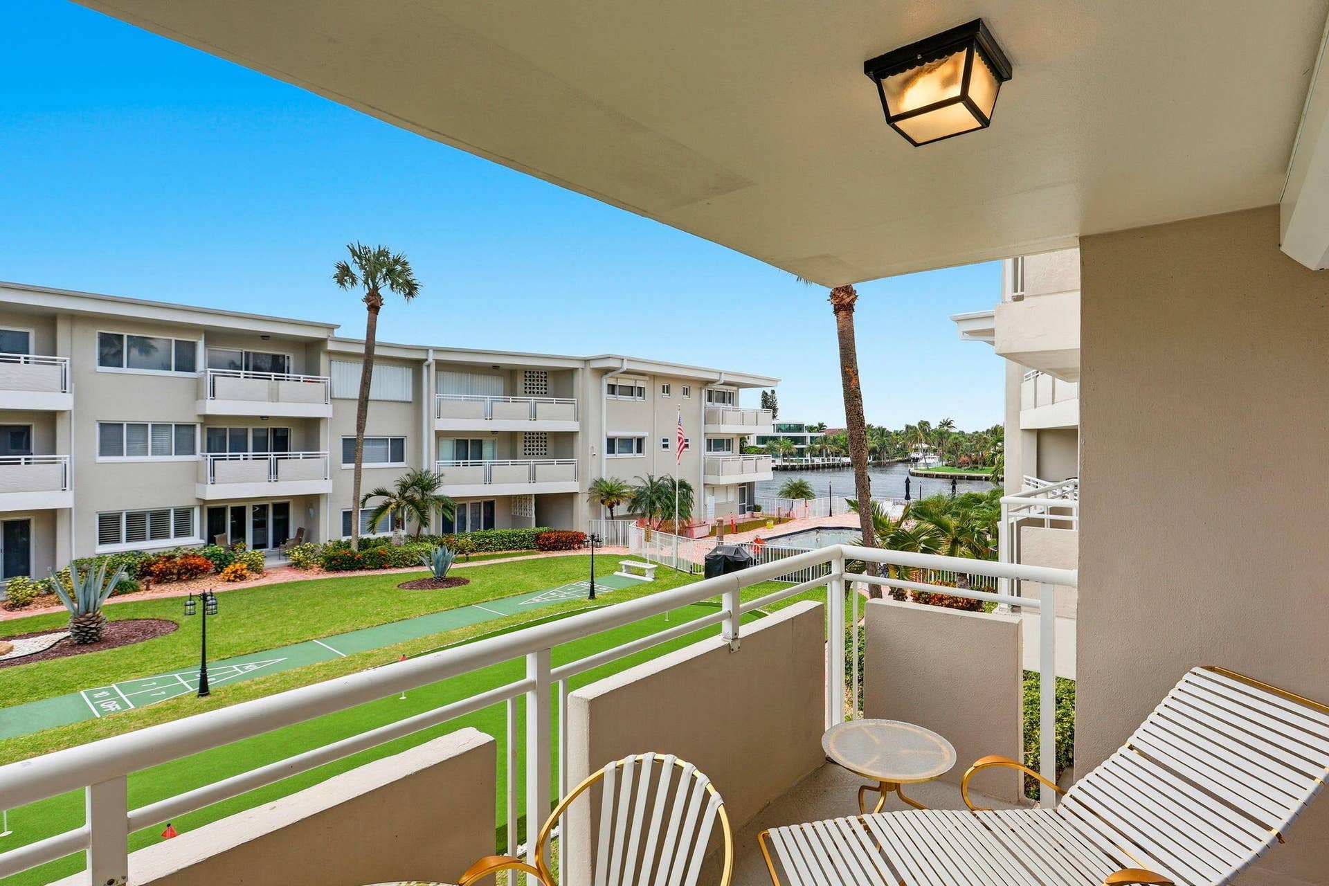 1198 Hillsboro Mile, #210, Hillsboro Beach, FL 33062 Balcony with white metal railing, overhead light fixture, and water frontage