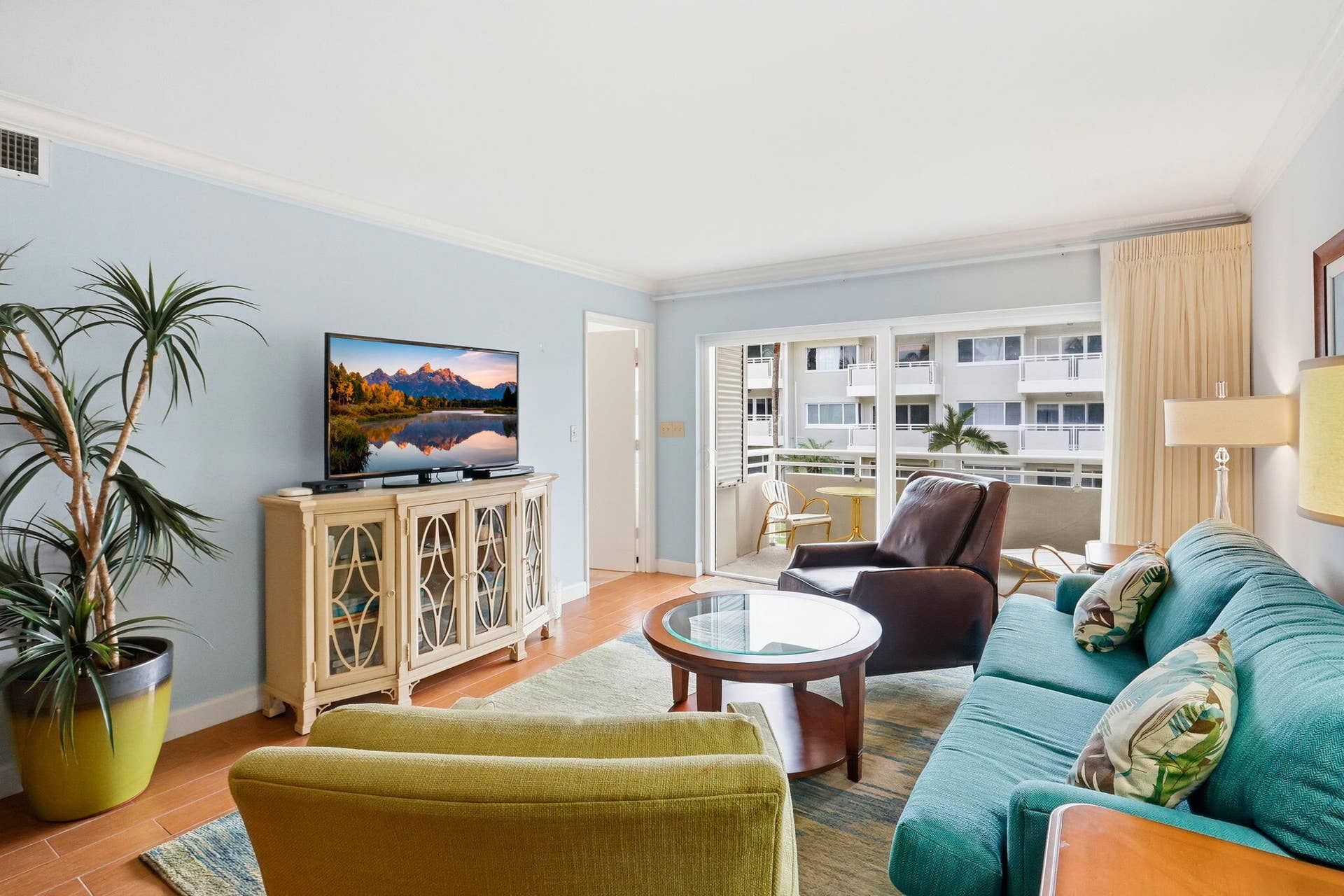 1198 Hillsboro Mile, #210, Hillsboro Beach, FL 33062 Light-toned wood-finish flooring, light blue wall paint, crown molding, and a sliding glass door to a balcony